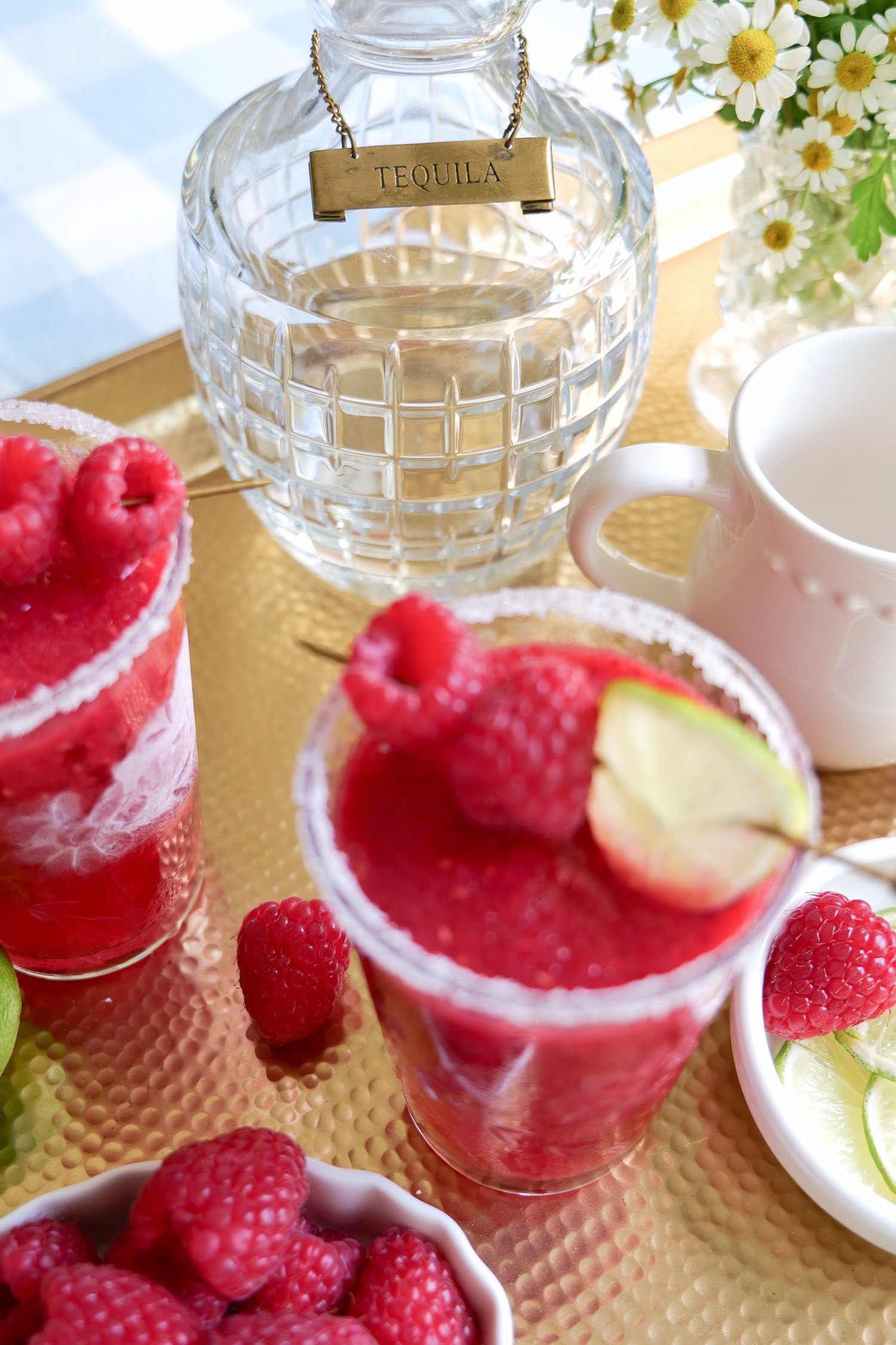 Frozen raspberry margarita with fresh raspberries and lime