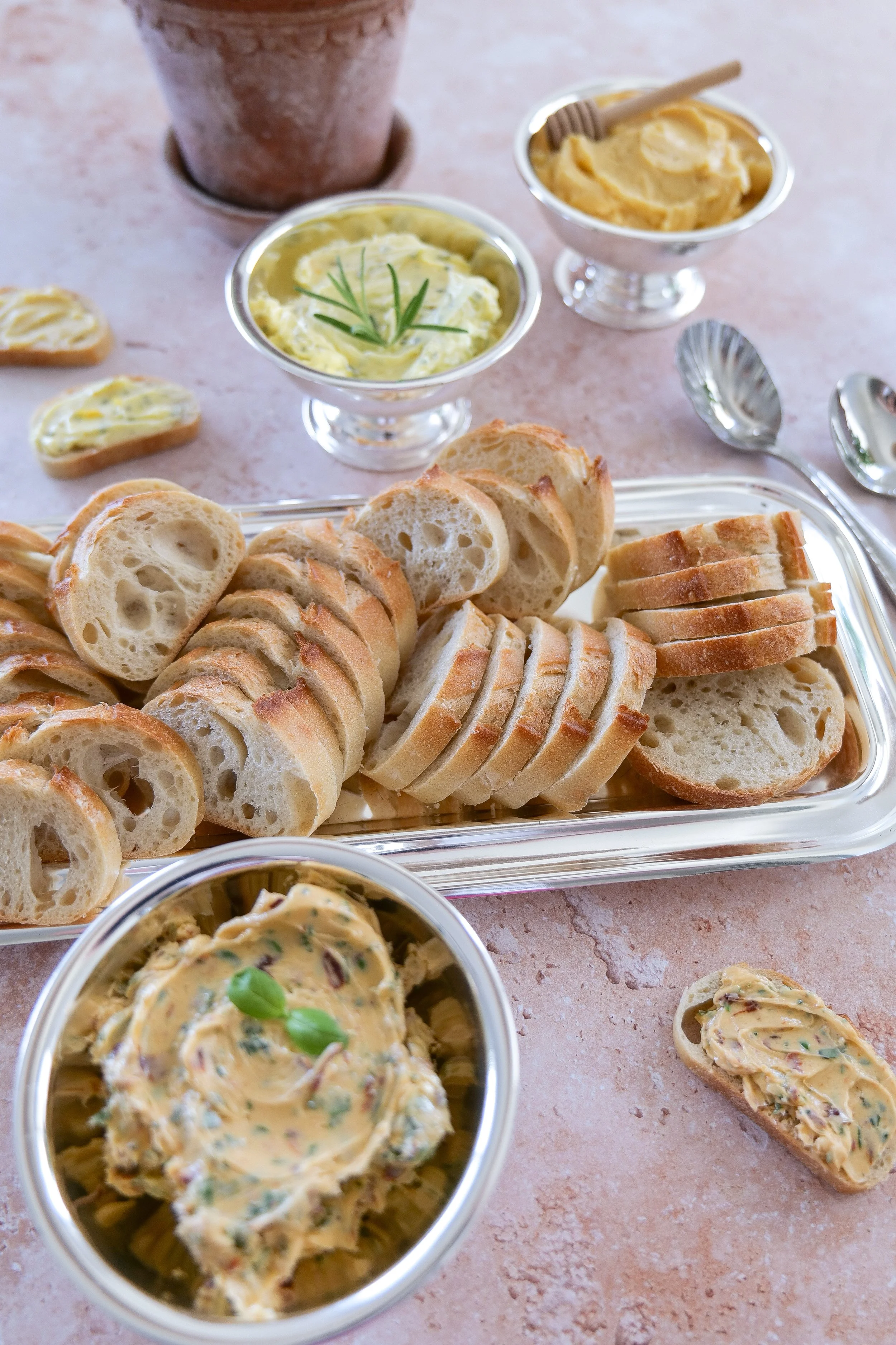 Flavored butter trio served in a metal cup alongside toasted baguette