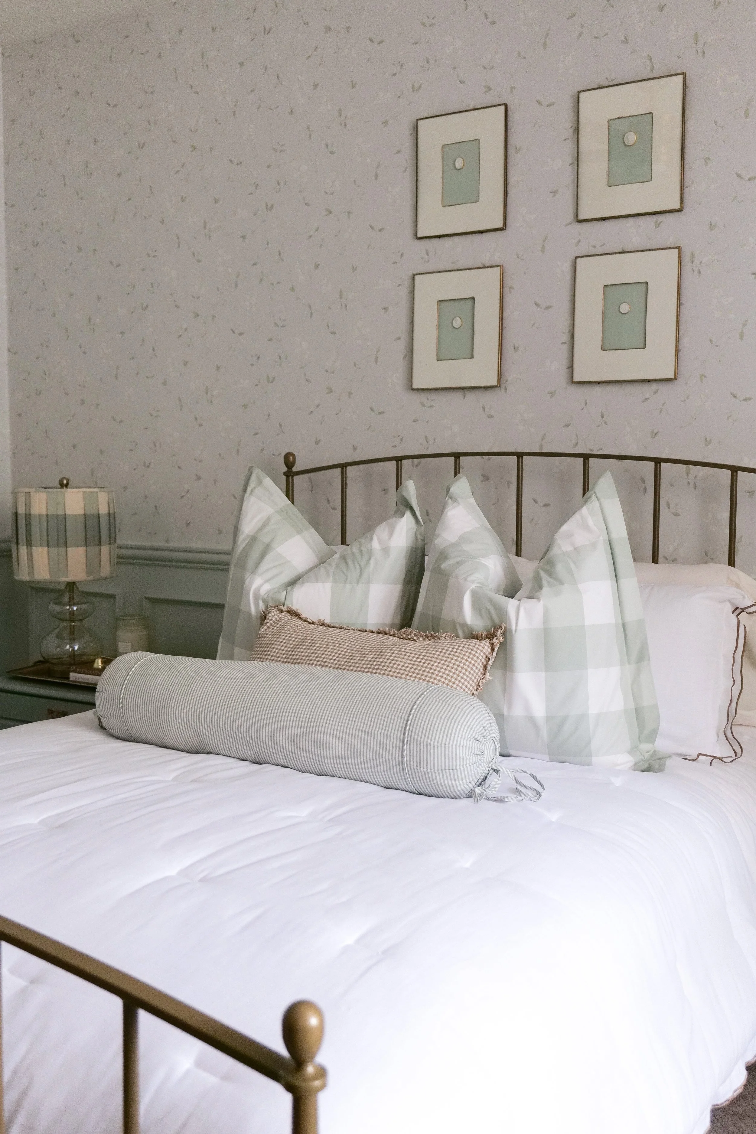 Layered bedding in a traditional blue guest bedroom with soft neutral textures.