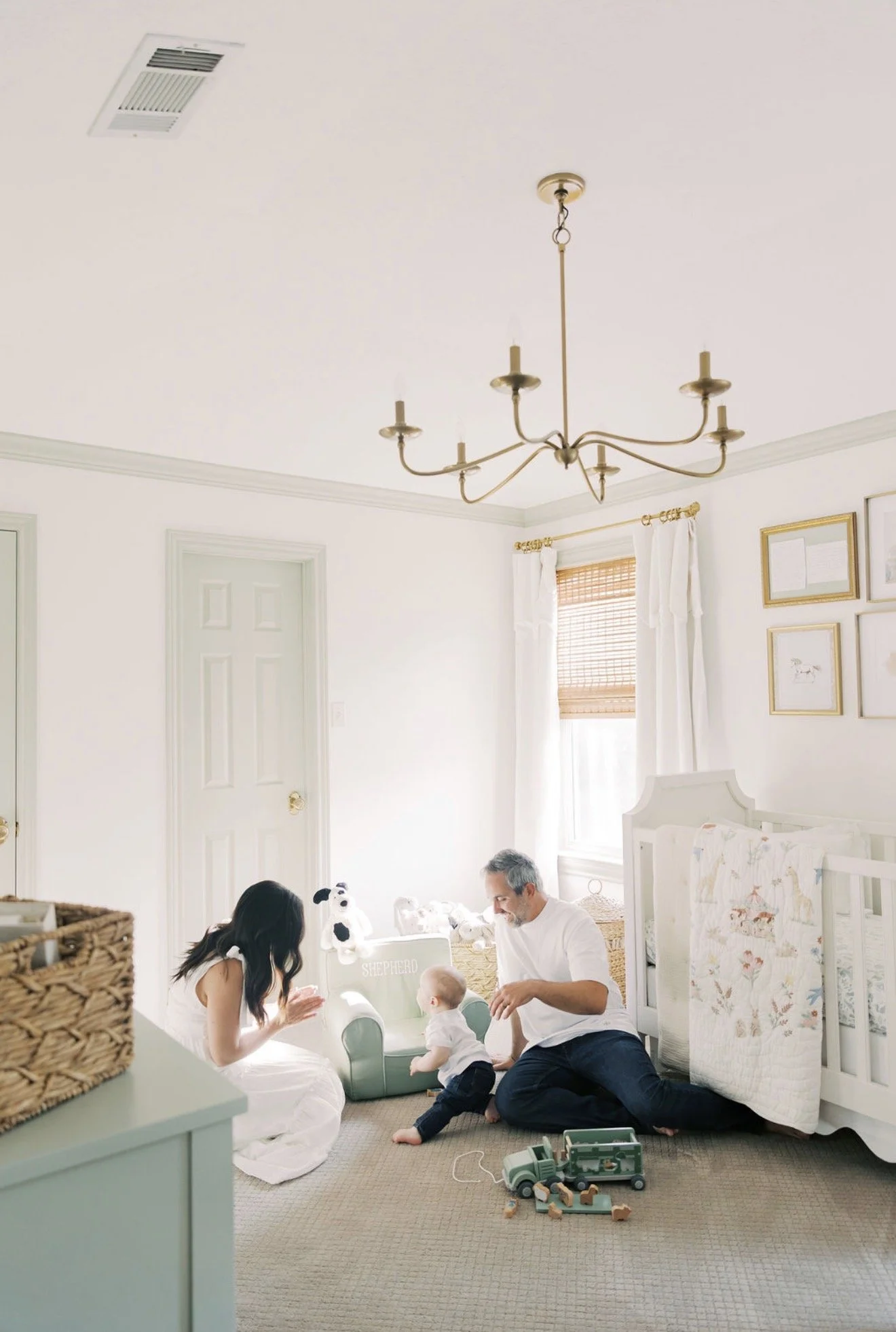 Mom and dad sitting on the nursery floor playing with their baby in their Texas home