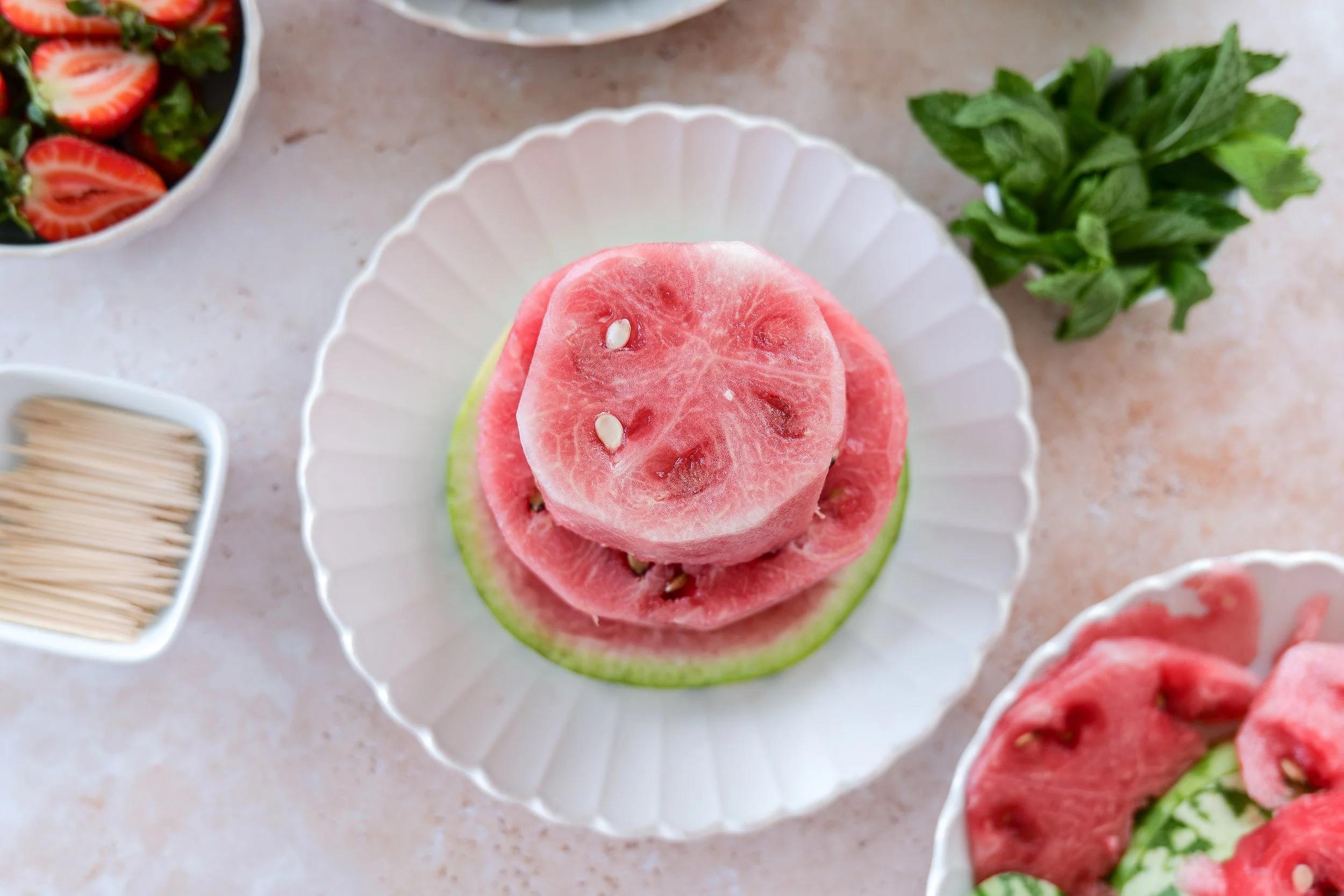Fresh watermelon trimmed into an even round tier before assembling a two-tier watermelon cake.