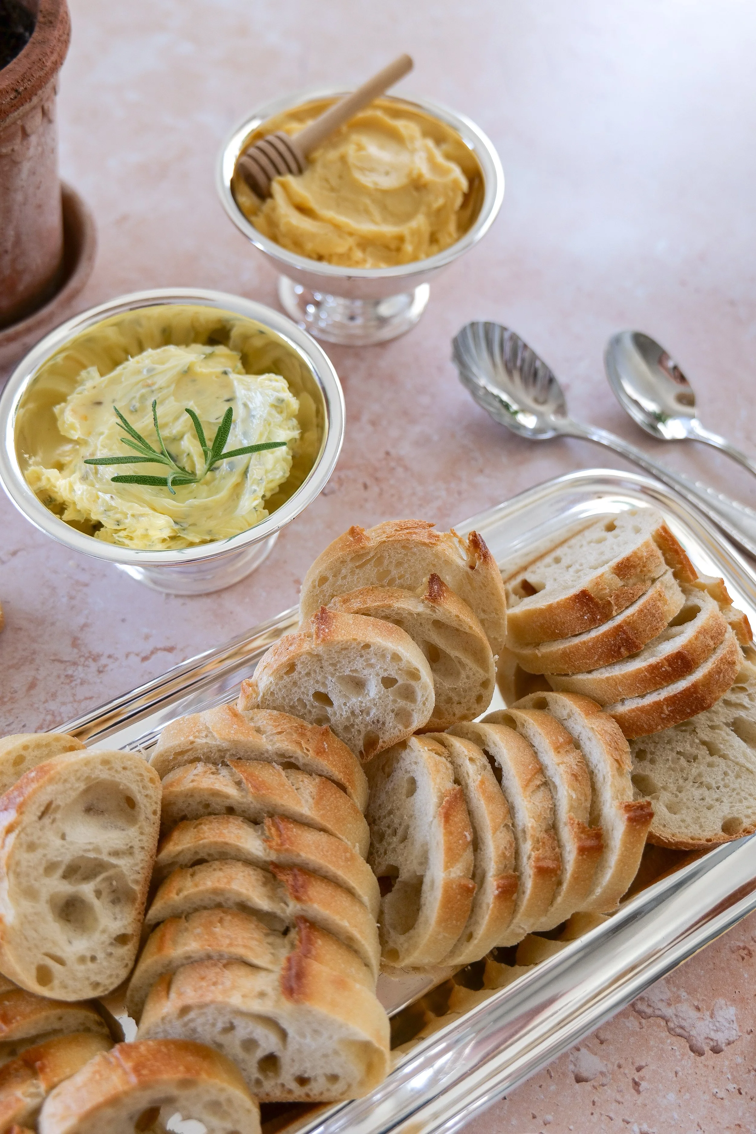 Homemade compound butter flight in a metal cup with toasted baguette