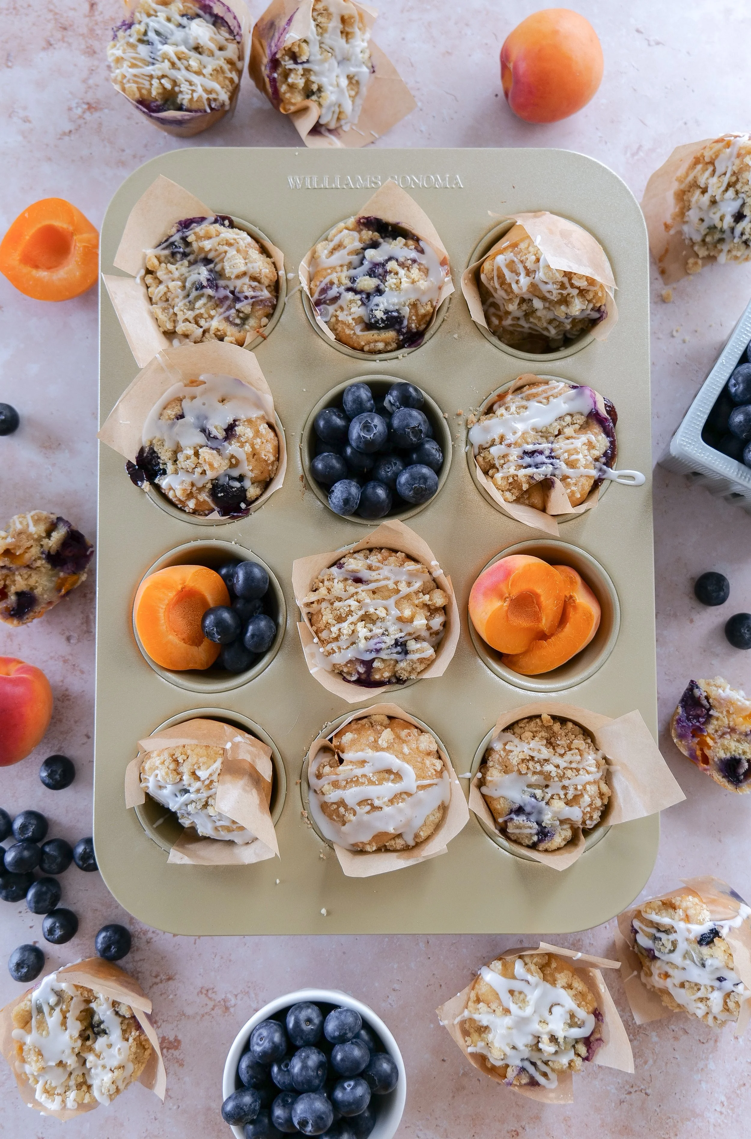 Moist blueberry apricot muffins filled with fresh fruit and topped with crumb topping.