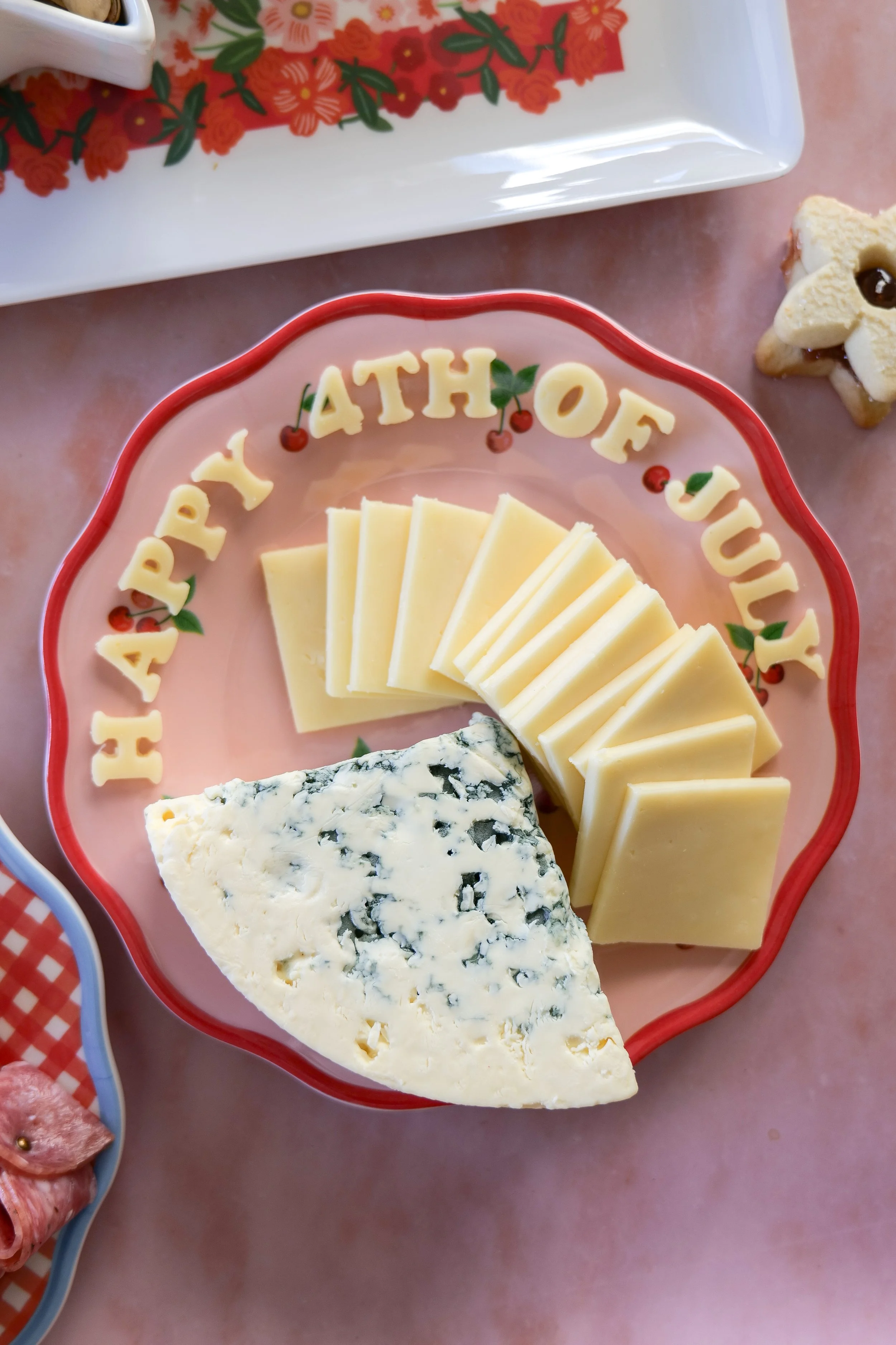 Patriotic charcuterie board featuring cheese, fruit, and festive summer snacks.