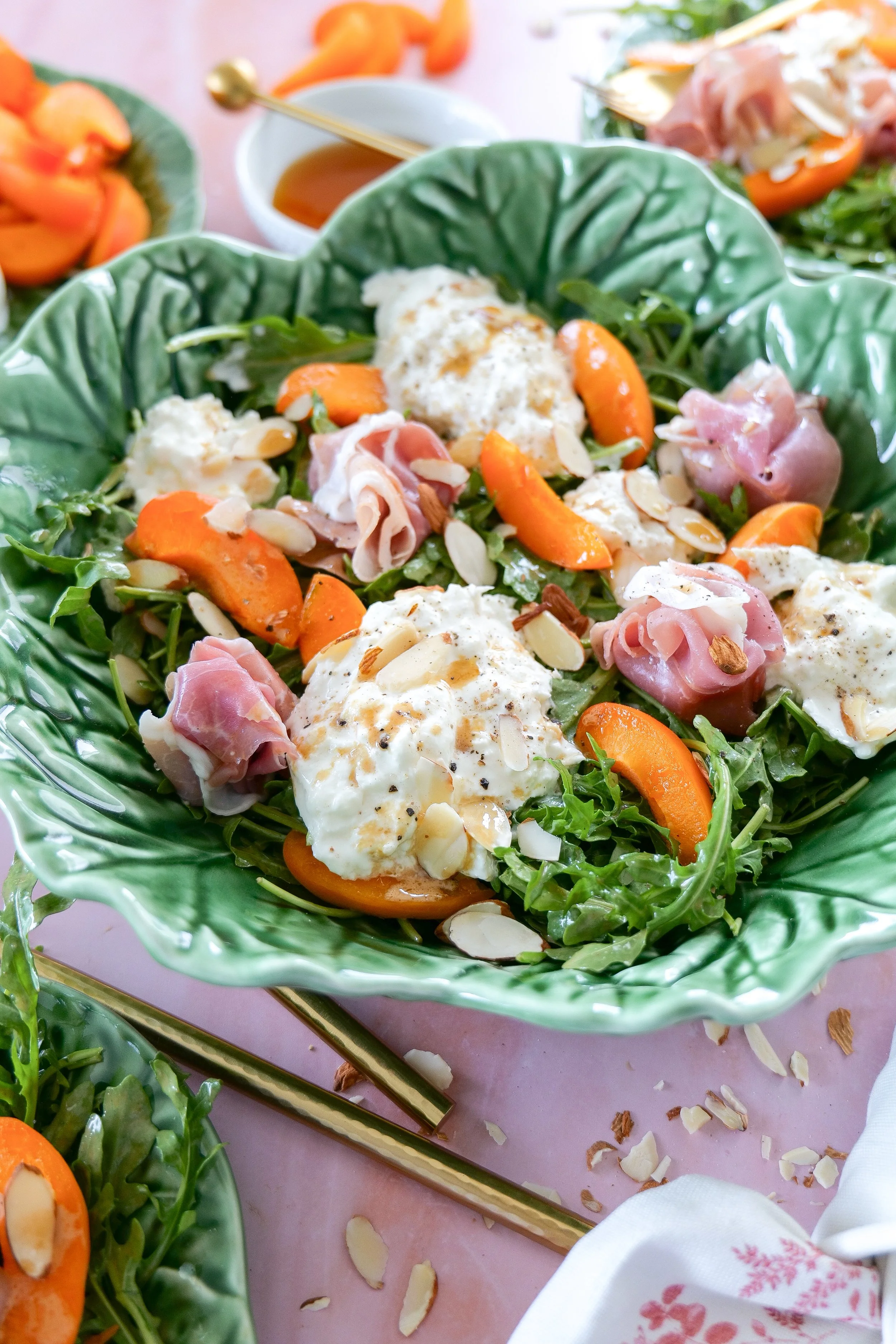 Summer burrata salad with arugula, apricots, and sliced prosciutto.