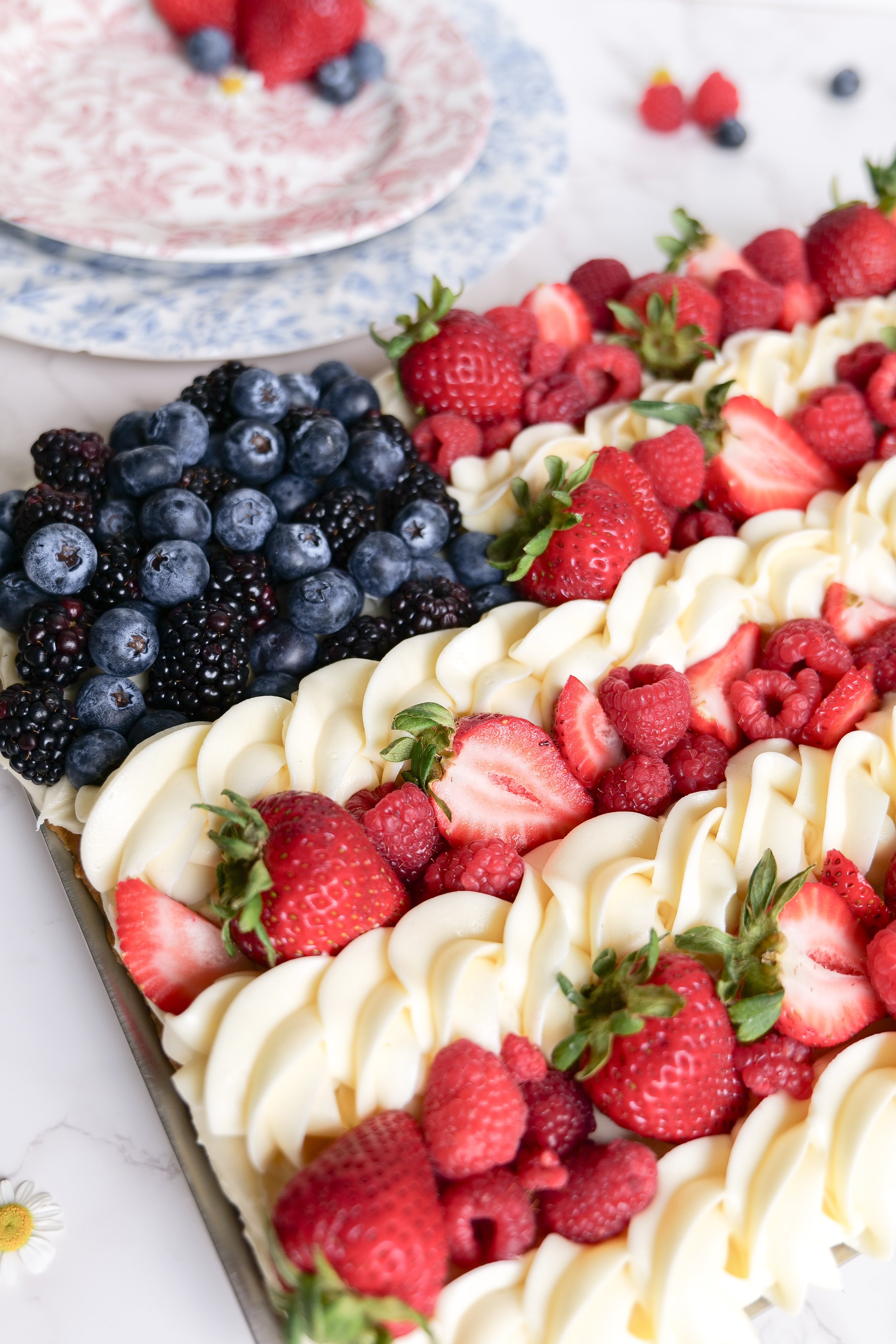 Easy sugar cookie fruit pizza recipe topped with cream cheese frosting and fresh berries