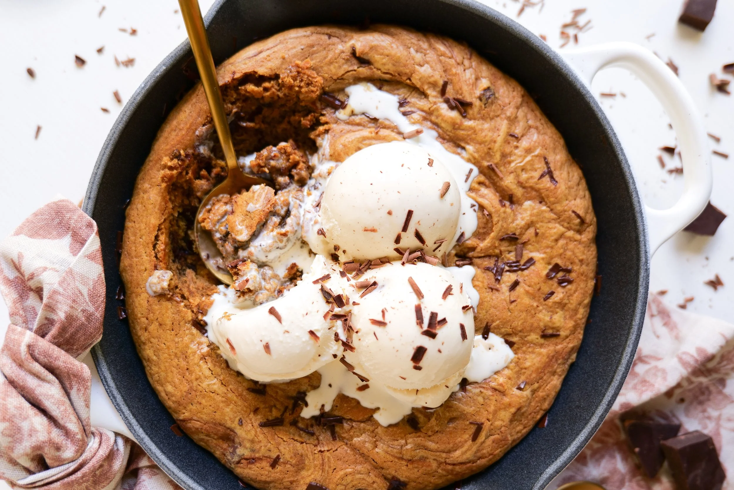 Pumpkin chocolate chip pizookie with a soft gooey center and vanilla ice cream