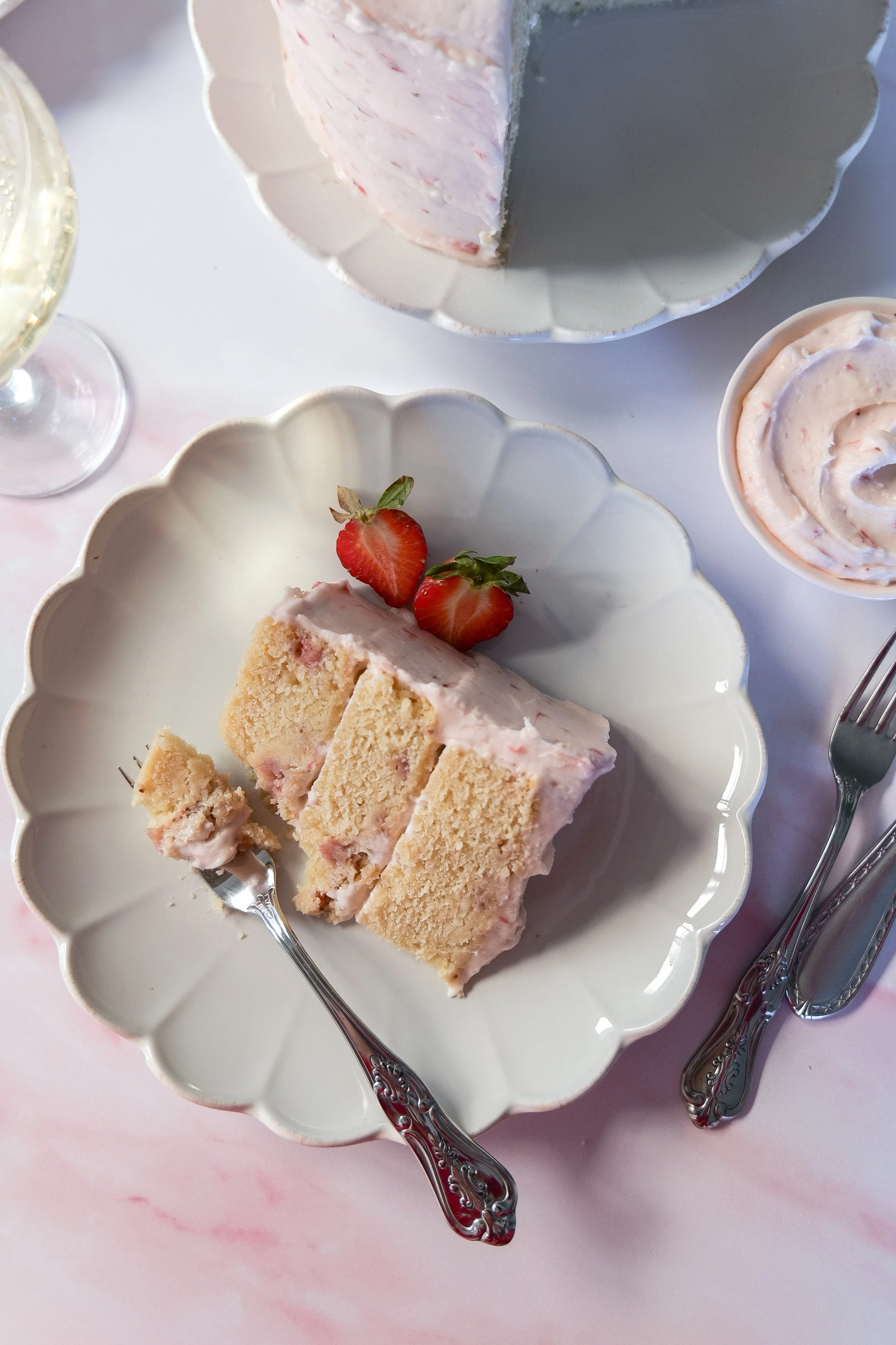 Three-layer Strawberry Champagne Cake covered in creamy strawberry frosting.