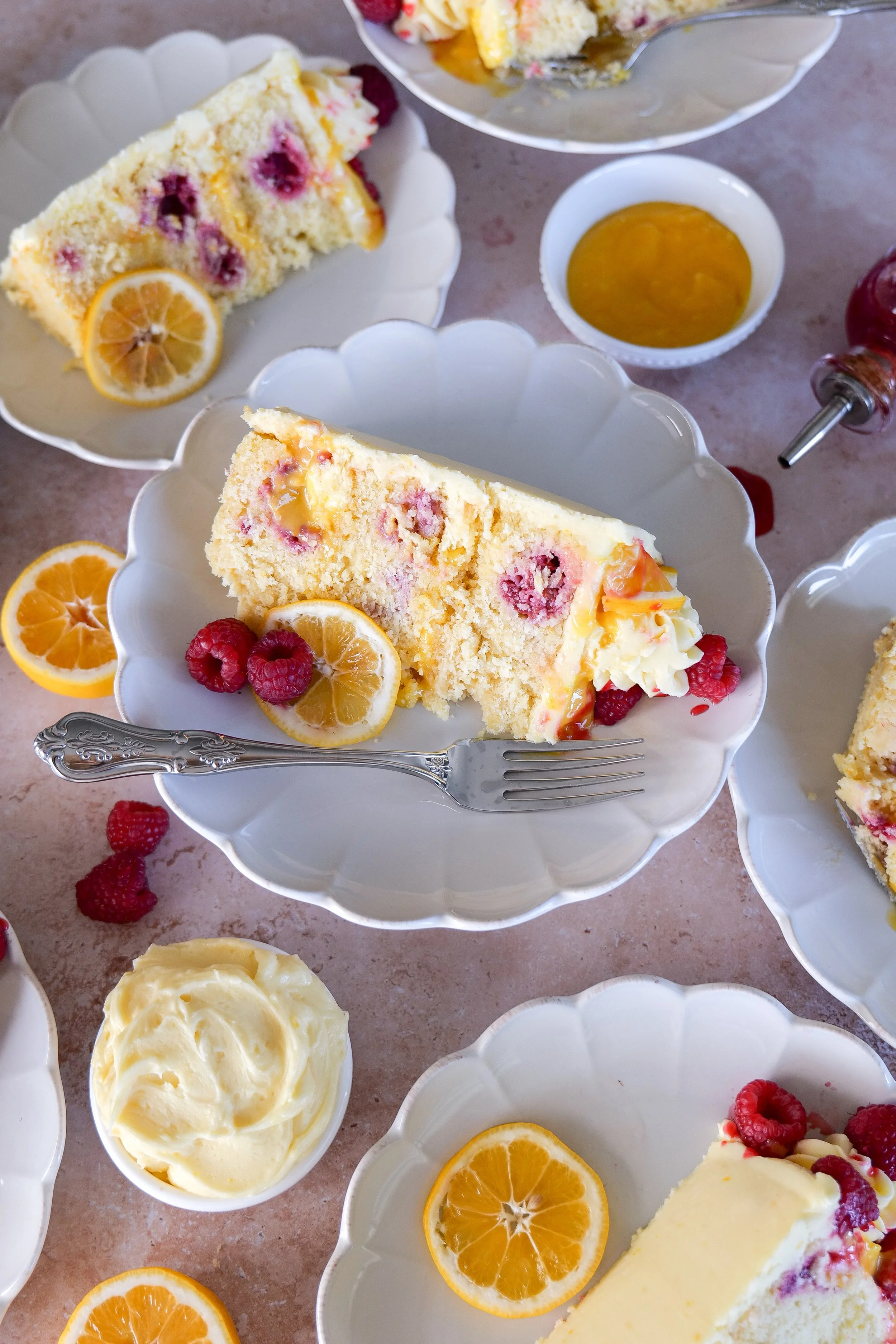 Lemon cake topped with fresh raspberries and powdered sugar.