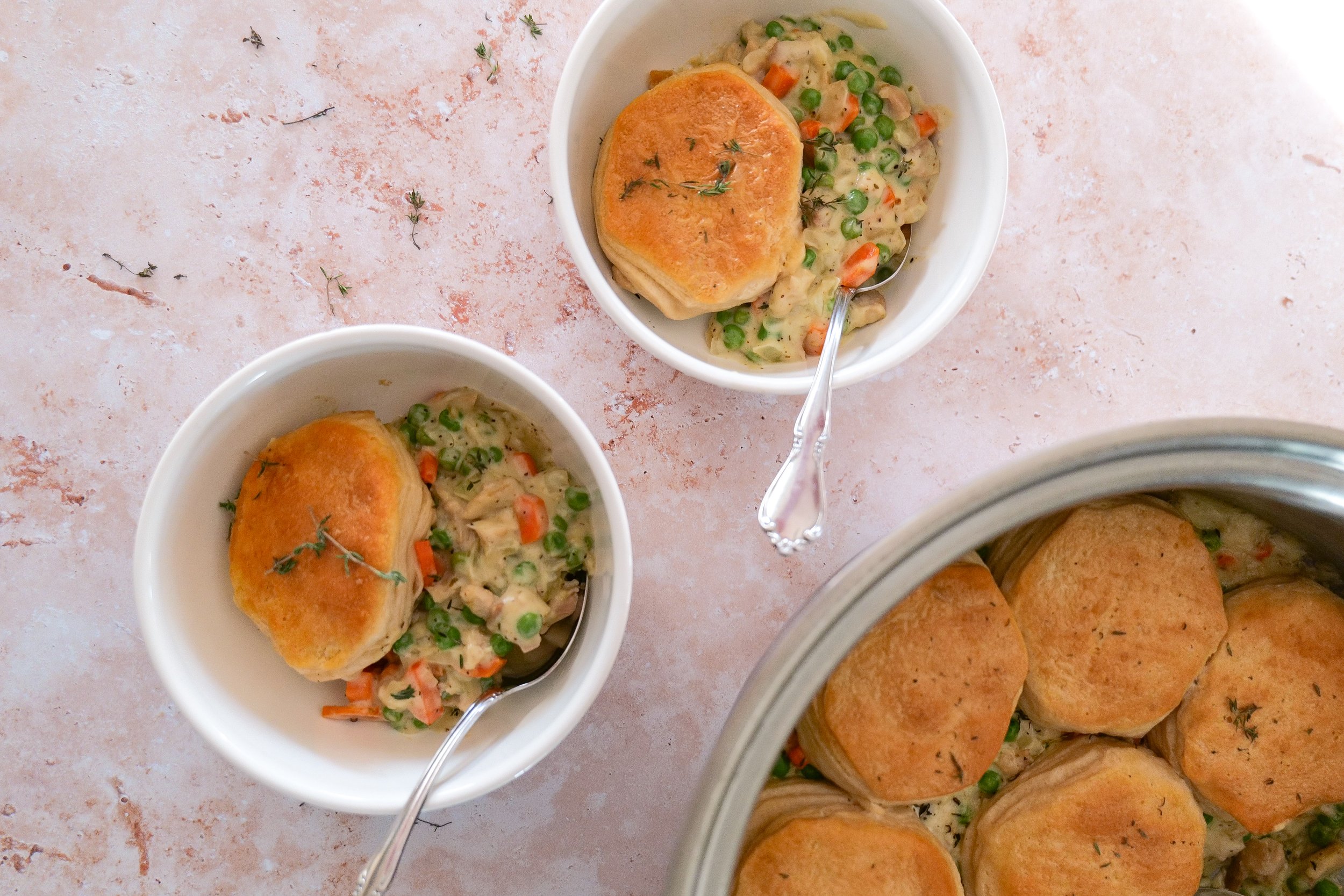 Golden brown biscuits baked over homemade chicken pot pie filling in an oven-safe skillet.