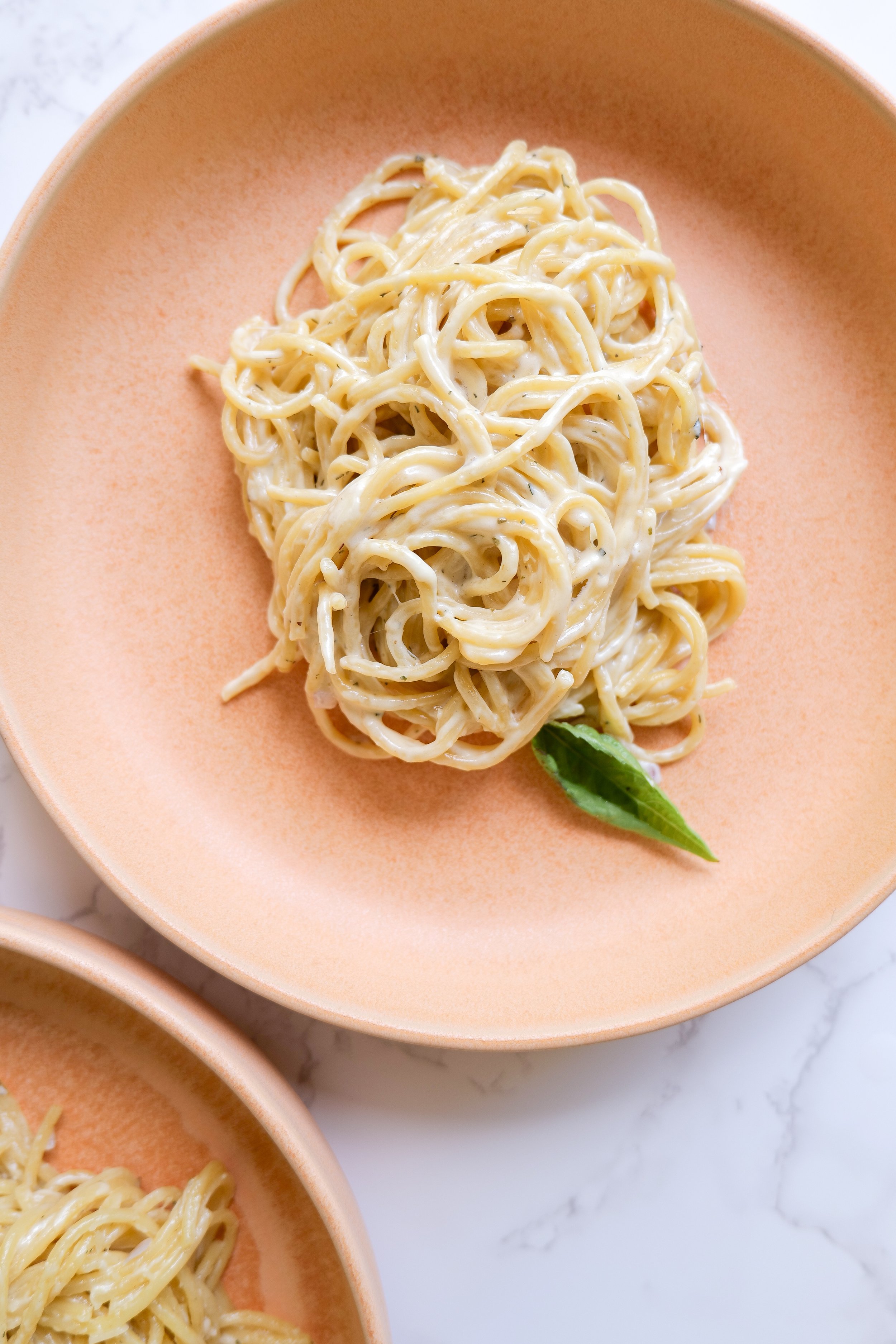 Creamy Parmesan pasta sauce coating freshly cooked pasta.