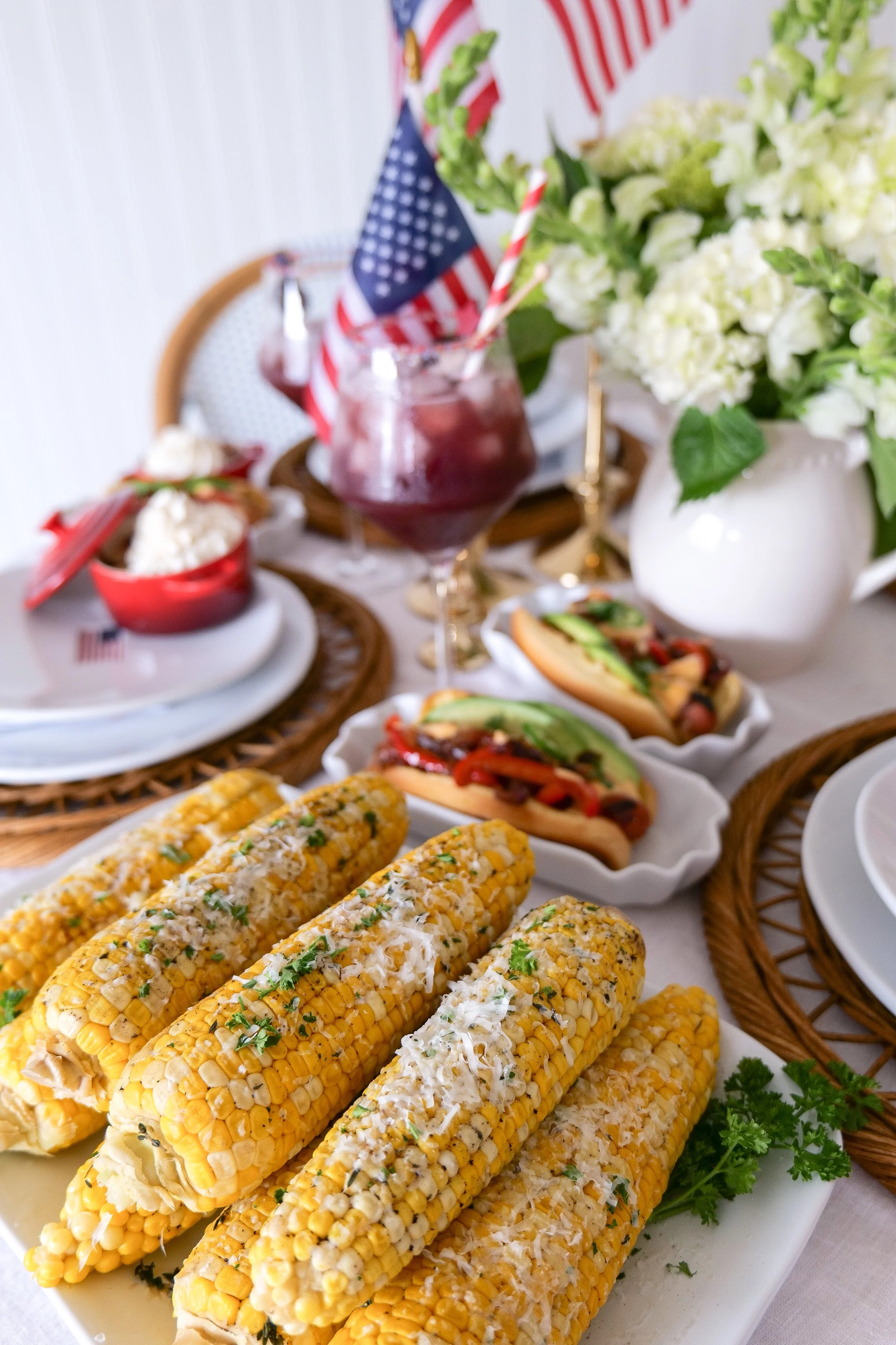 Summer hostess holding corn on the cob during Americana entertaining