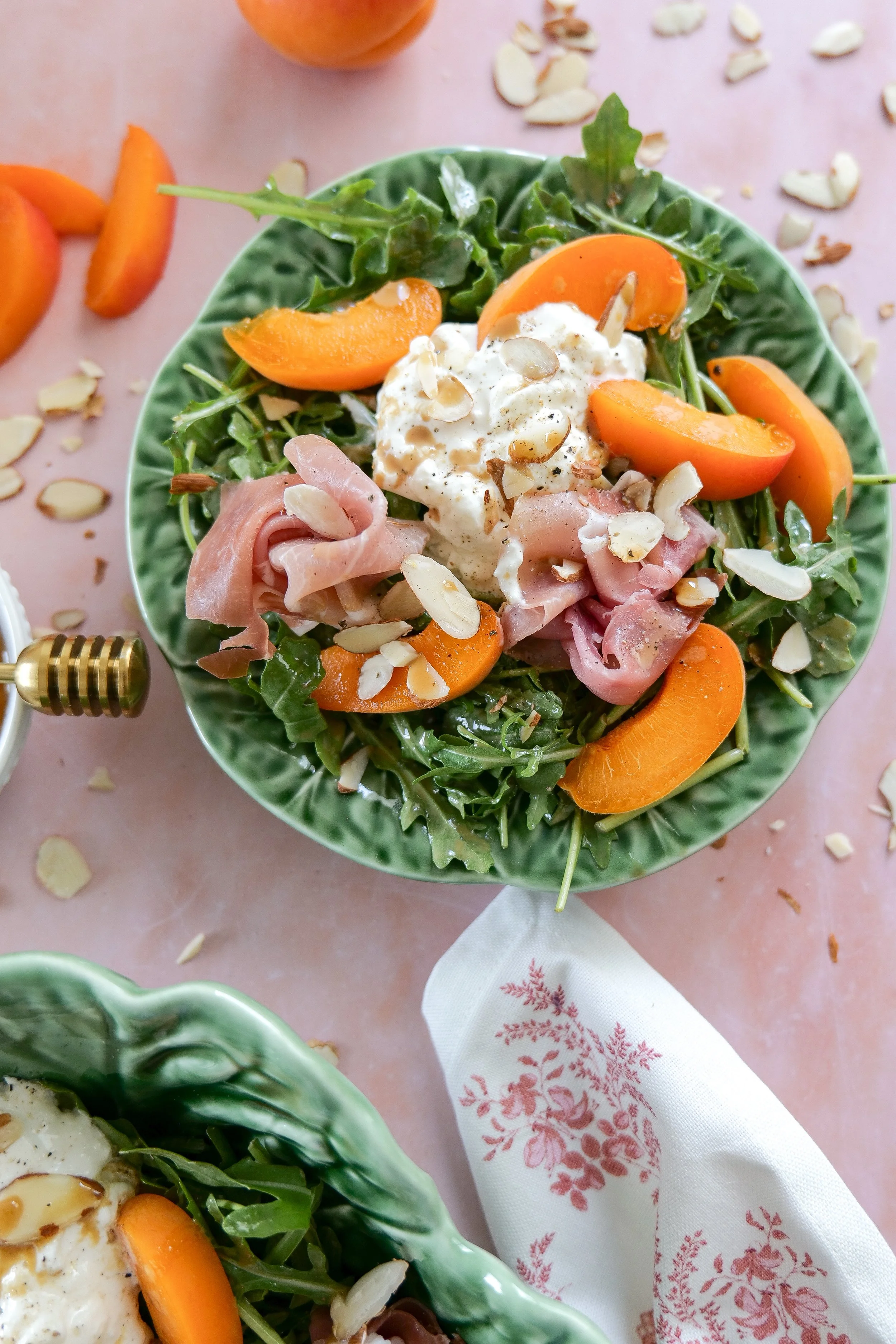 Summer salad with prosciutto, burrata, apricots, and arugula.