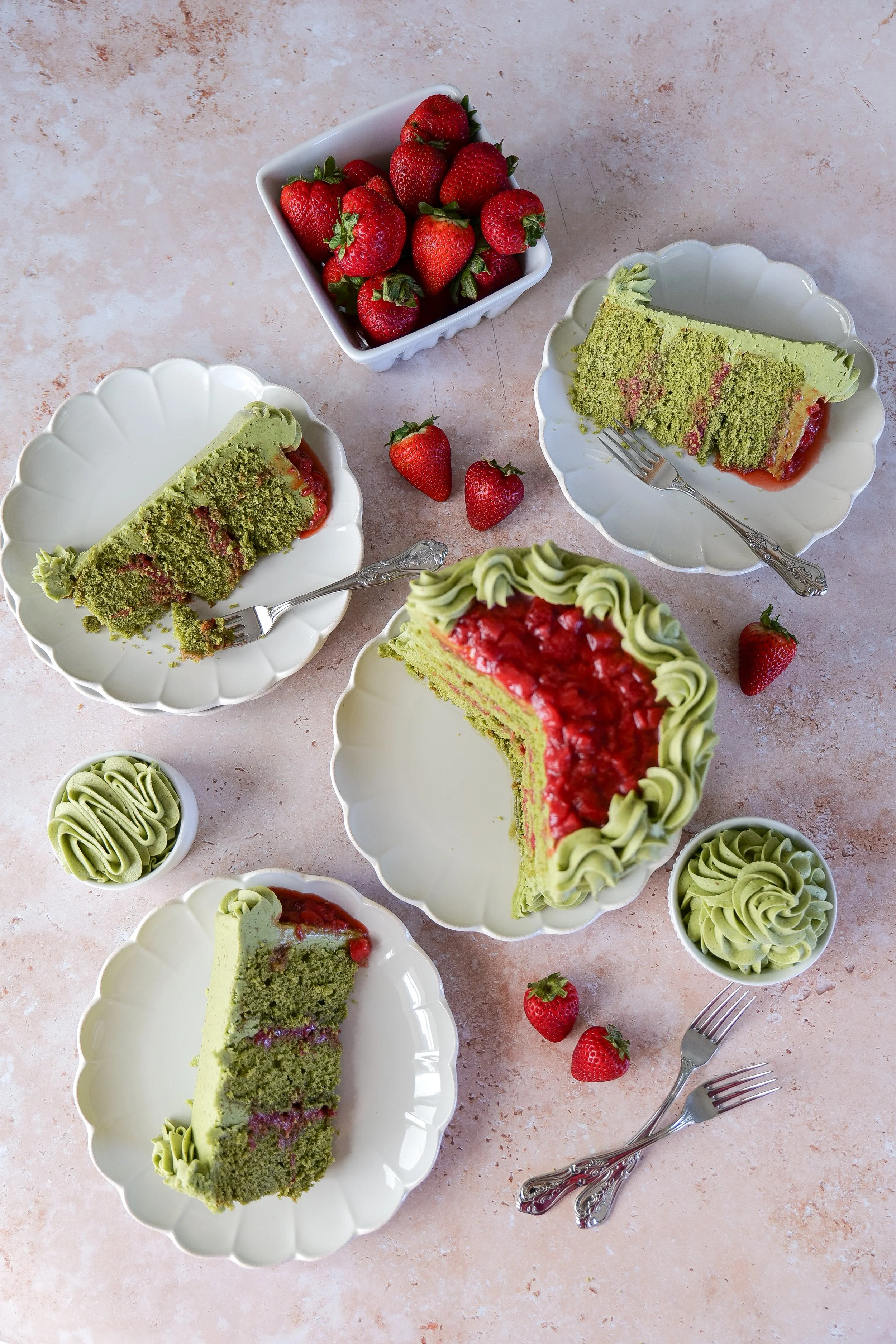 Moist matcha strawberry cake slices with brown butter frosting on a dessert plate