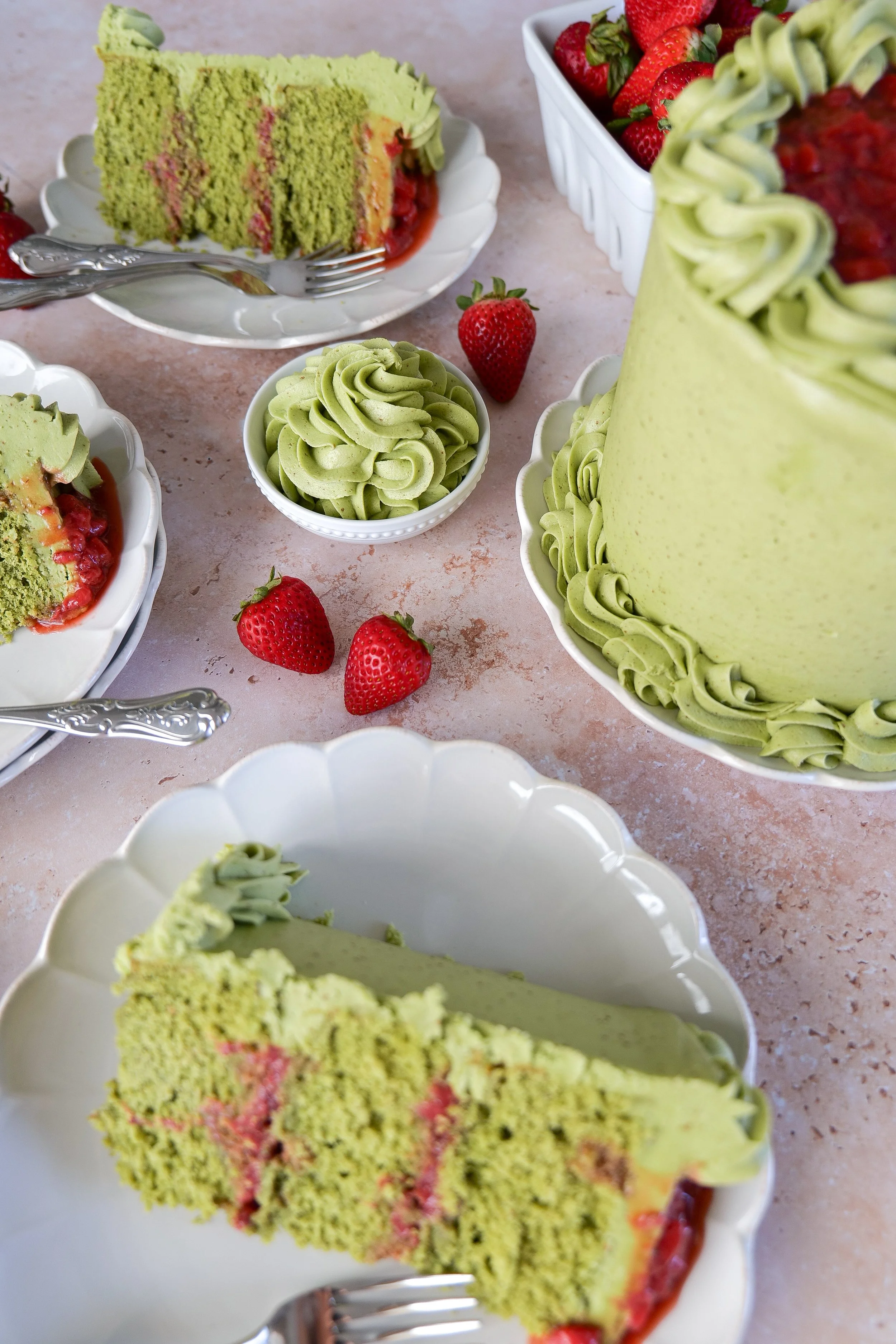 Homemade matcha strawberry cake slices topped with fresh strawberries