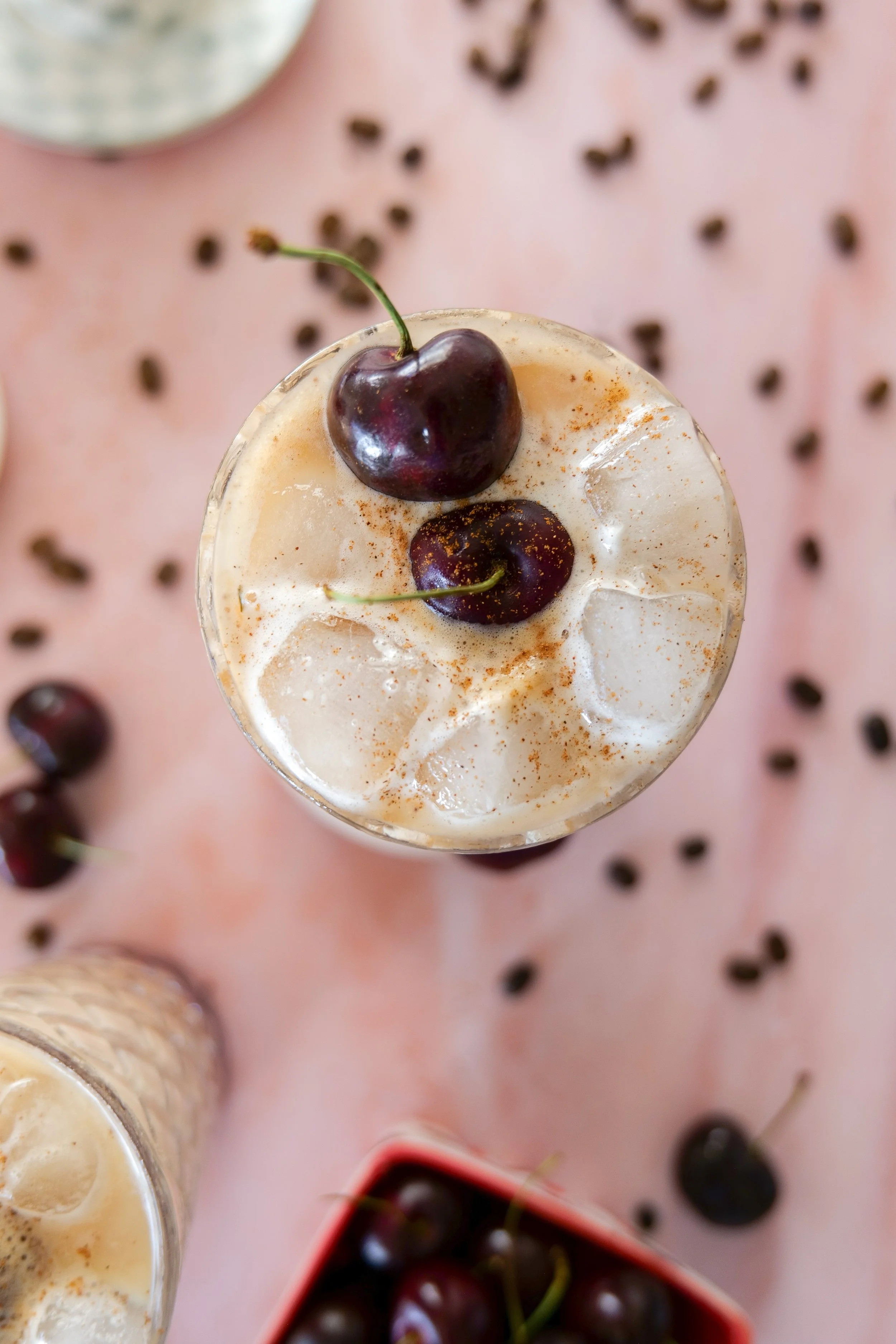 Homemade Iced Cherry Cobbler Latte served over ice with creamy cold foam and fresh cherry garnish.