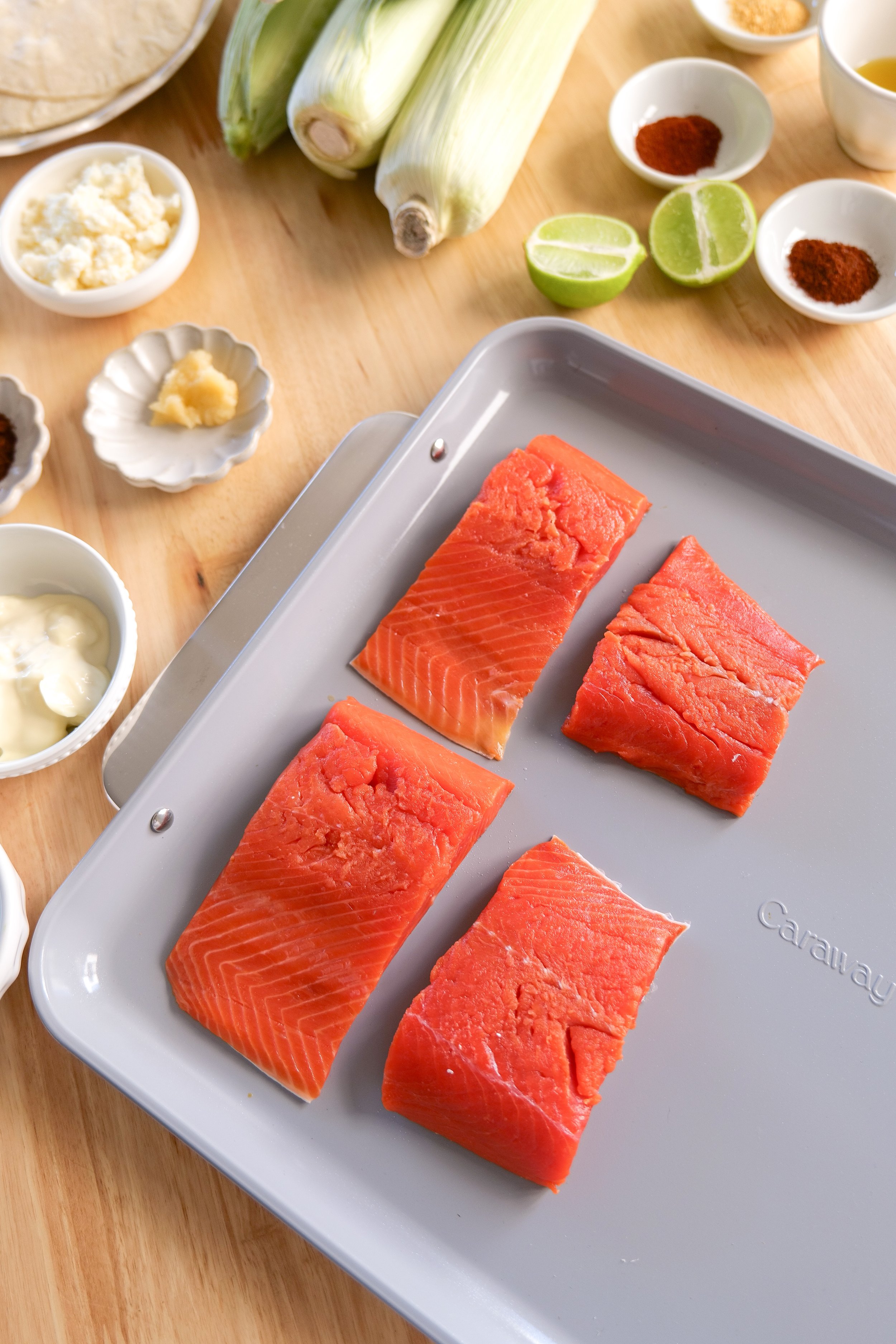 Fresh raw salmon fillets arranged and ready to be seasoned for homemade salmon tacos with elote corn salsa.