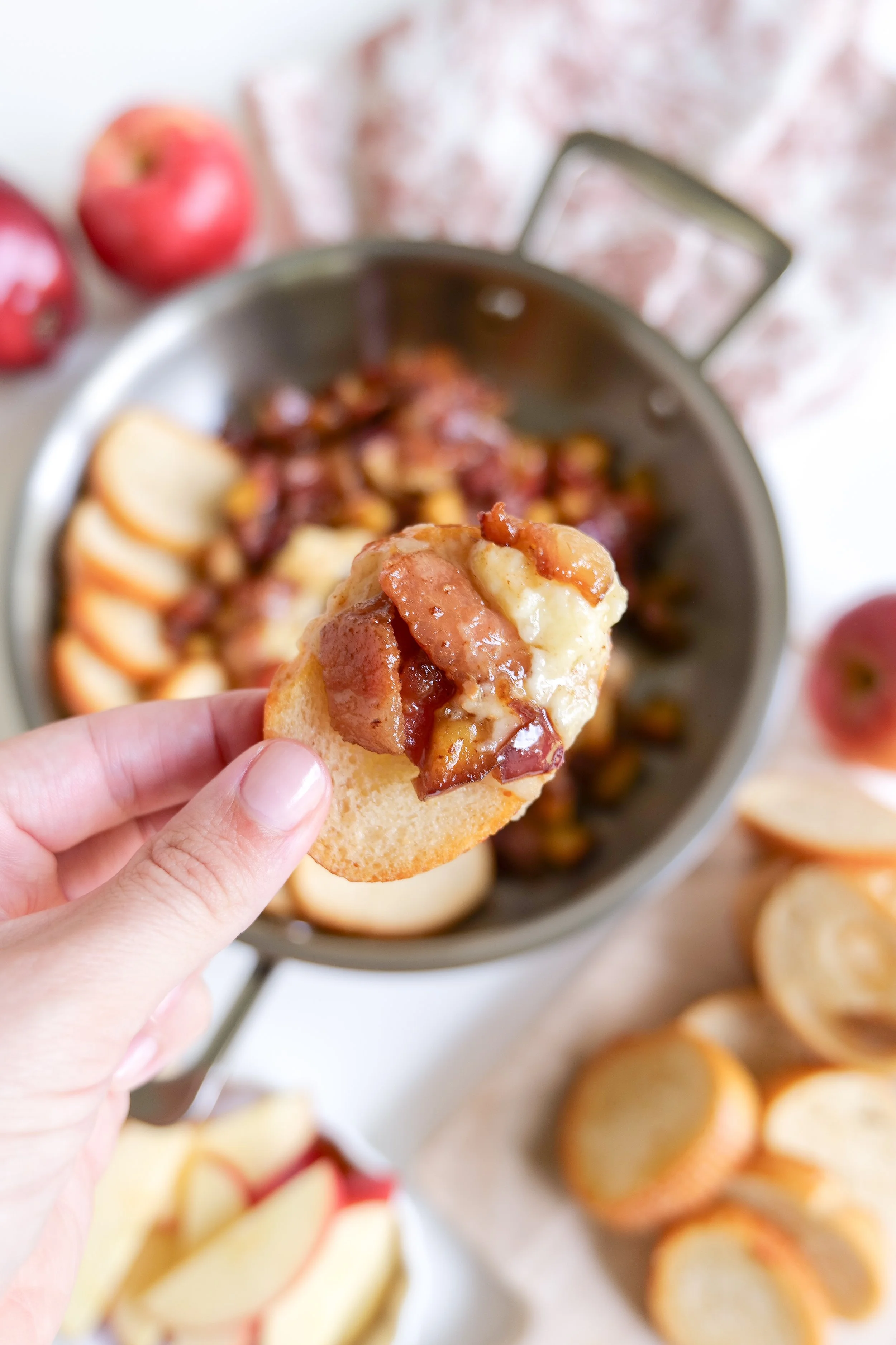 Holiday baked brie appetizer topped with apples and bacon for entertaining guests.