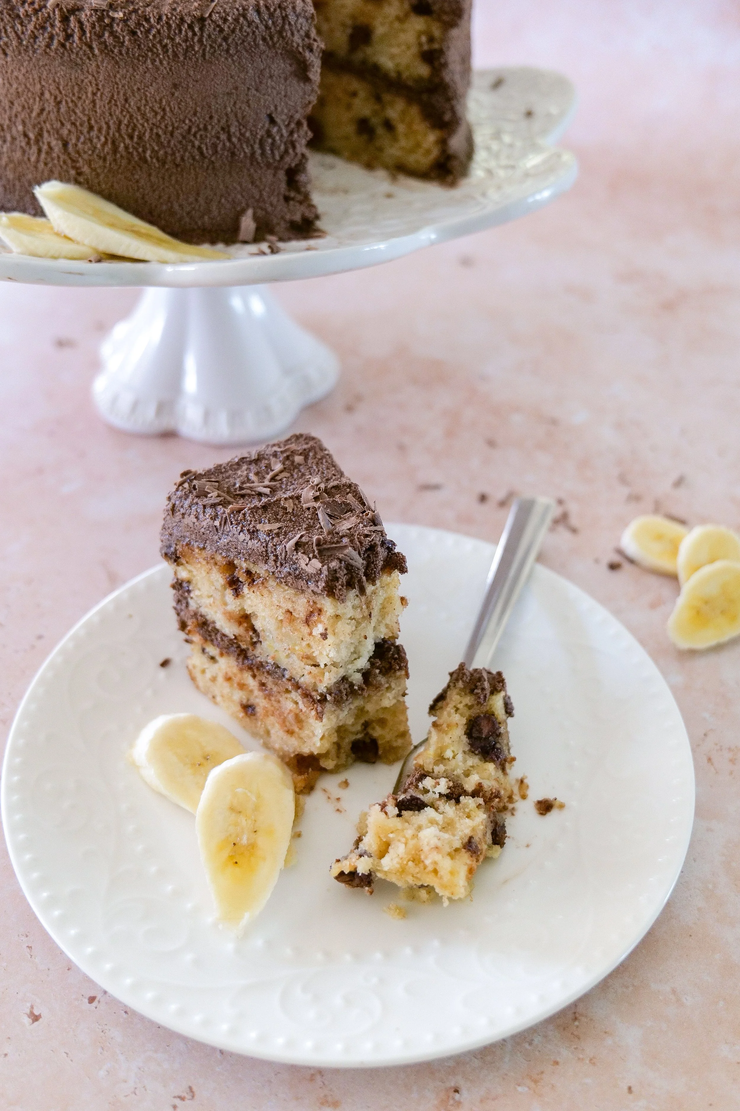 Homemade banana layer cake covered with fluffy whipped chocolate ganache.