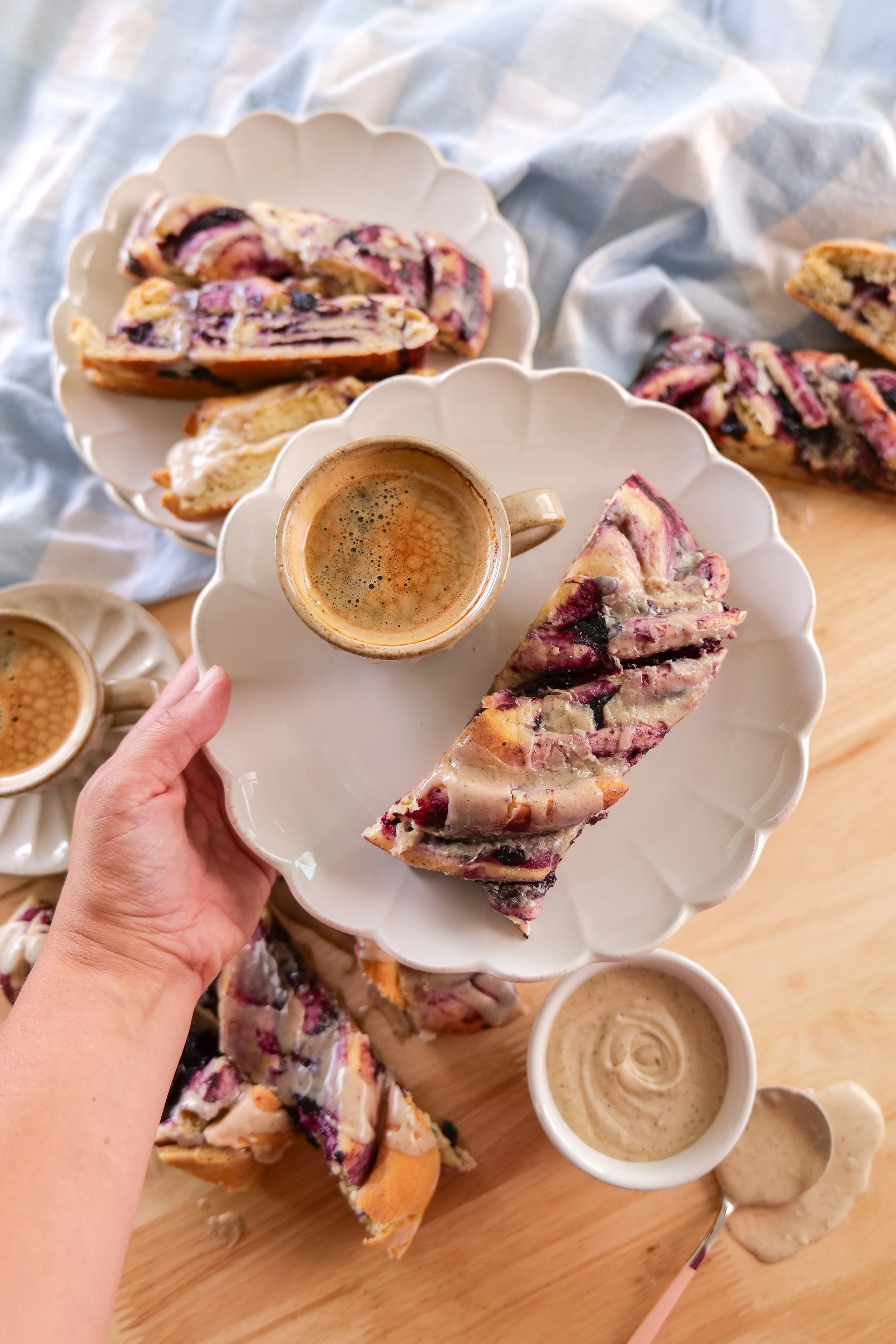 Homemade blueberry cinnamon roll loaf topped with sweet brown butter icing and blueberry-filled swirls.