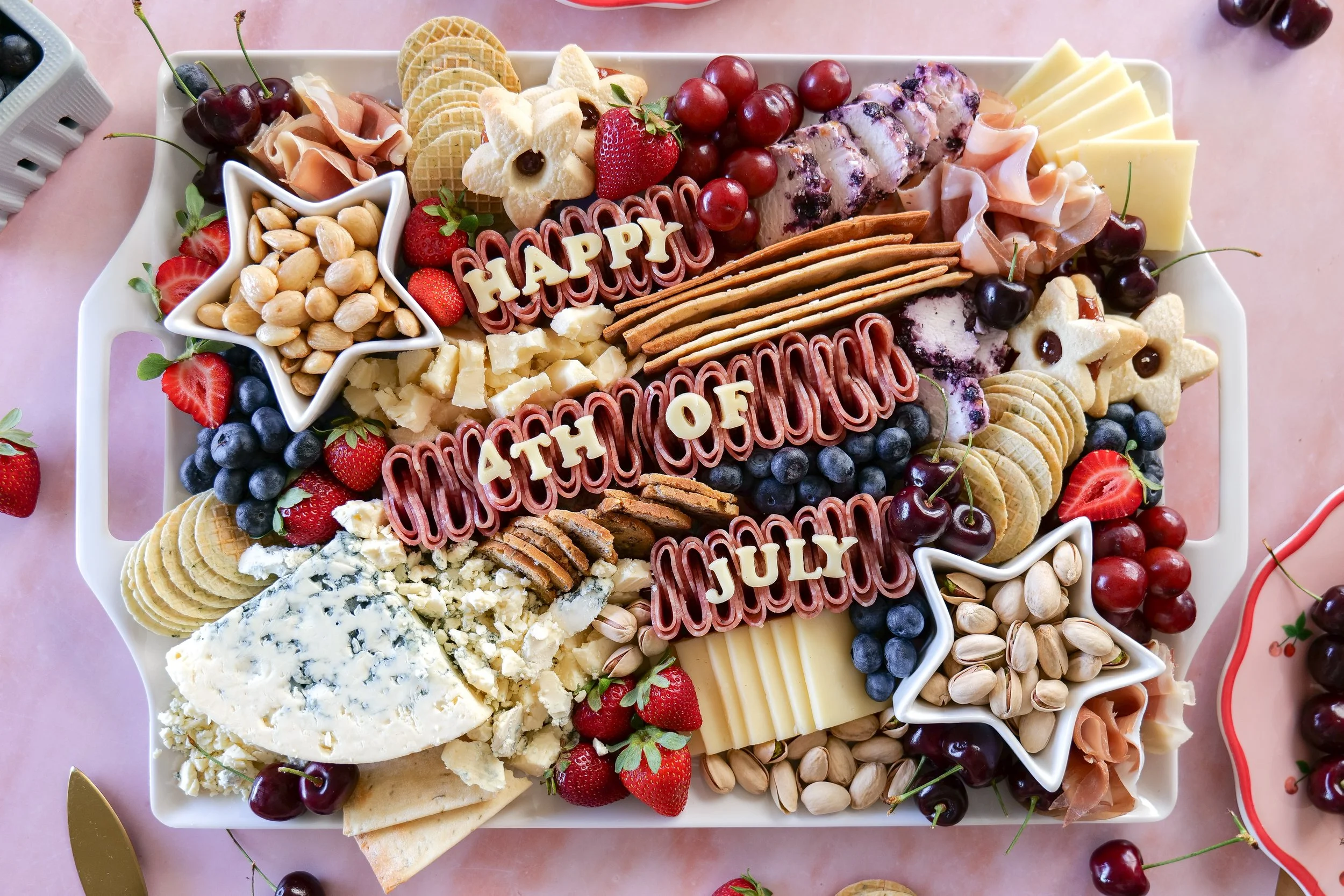Fourth of July charcuterie board arranged with festive red, white, and blue foods.