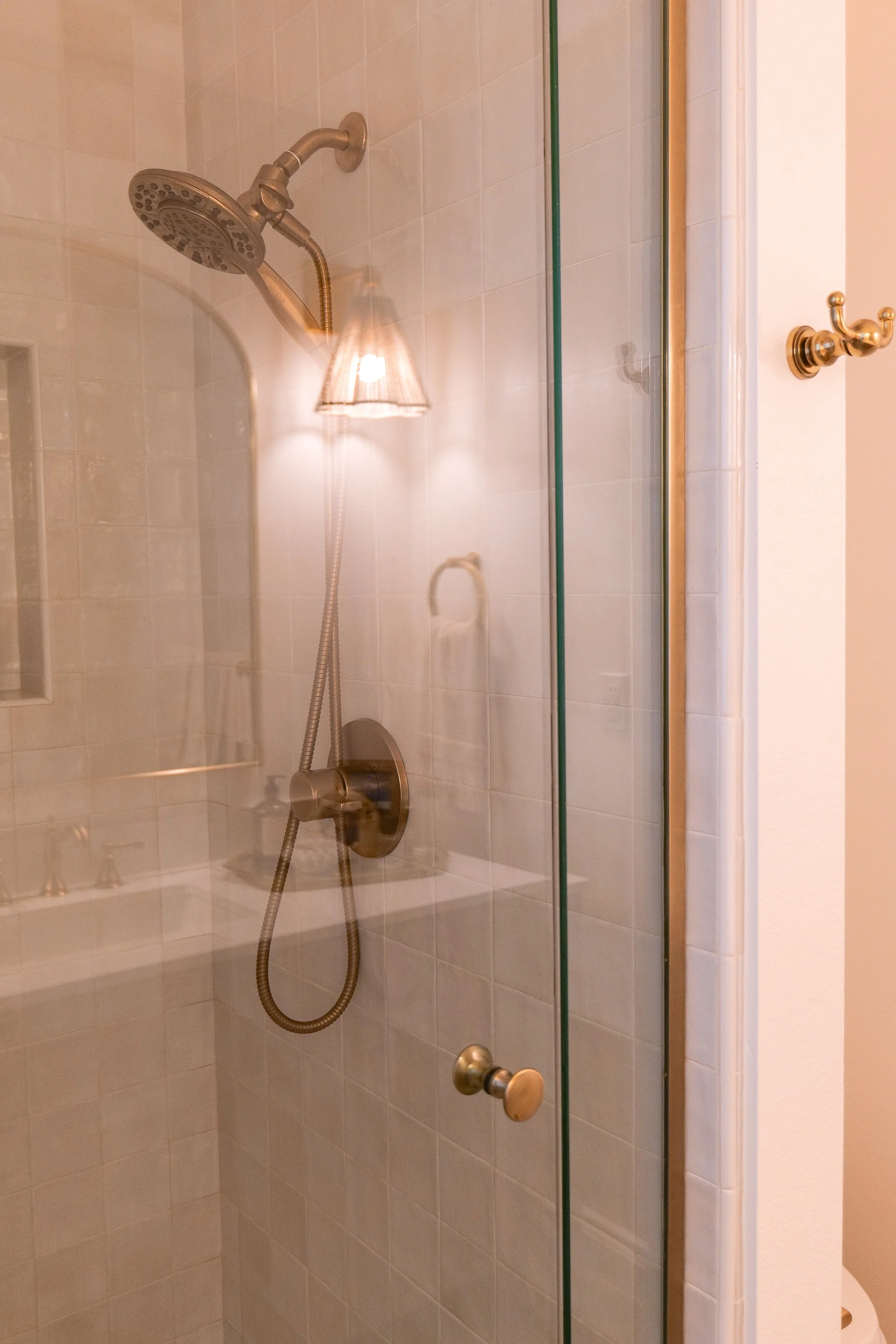 Finished bathroom remodel with blue floor tile, white walls, and warm neutral finishes.