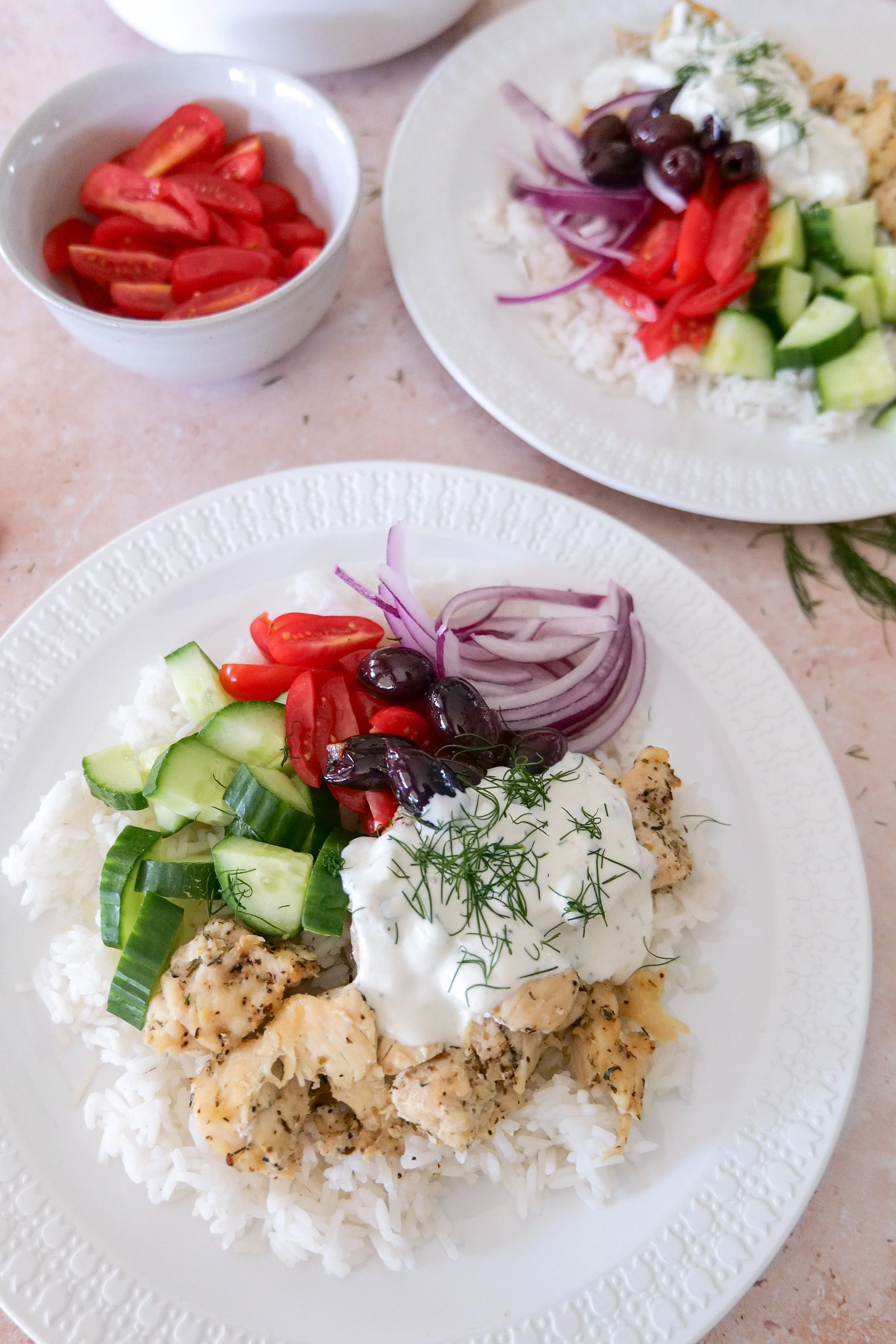 Greek-inspired herb chicken and rice bowl with colorful vegetables, Kalamata olives and tzatziki.