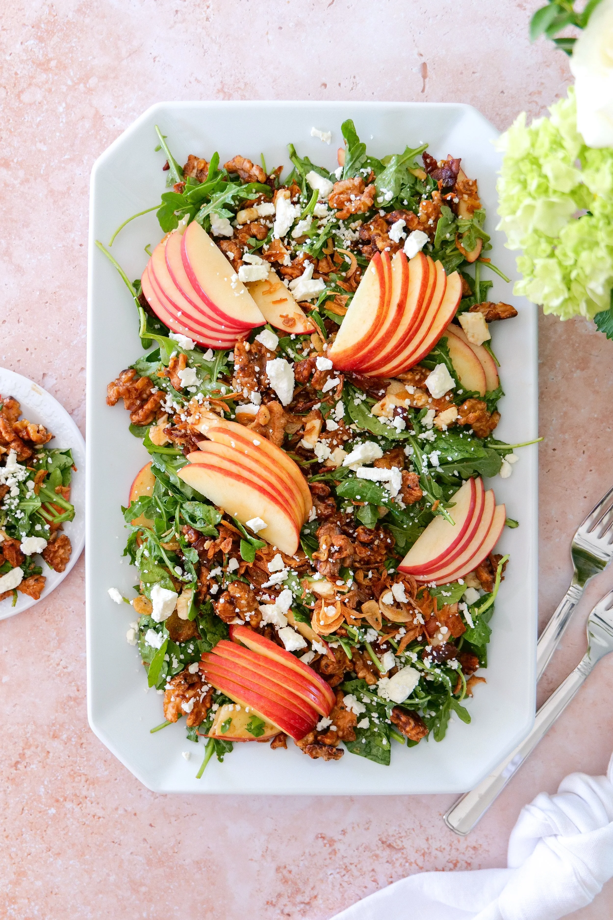 Colorful fall salad arranged with apples, feta, maple walnuts, bacon and golden crispy shallots.