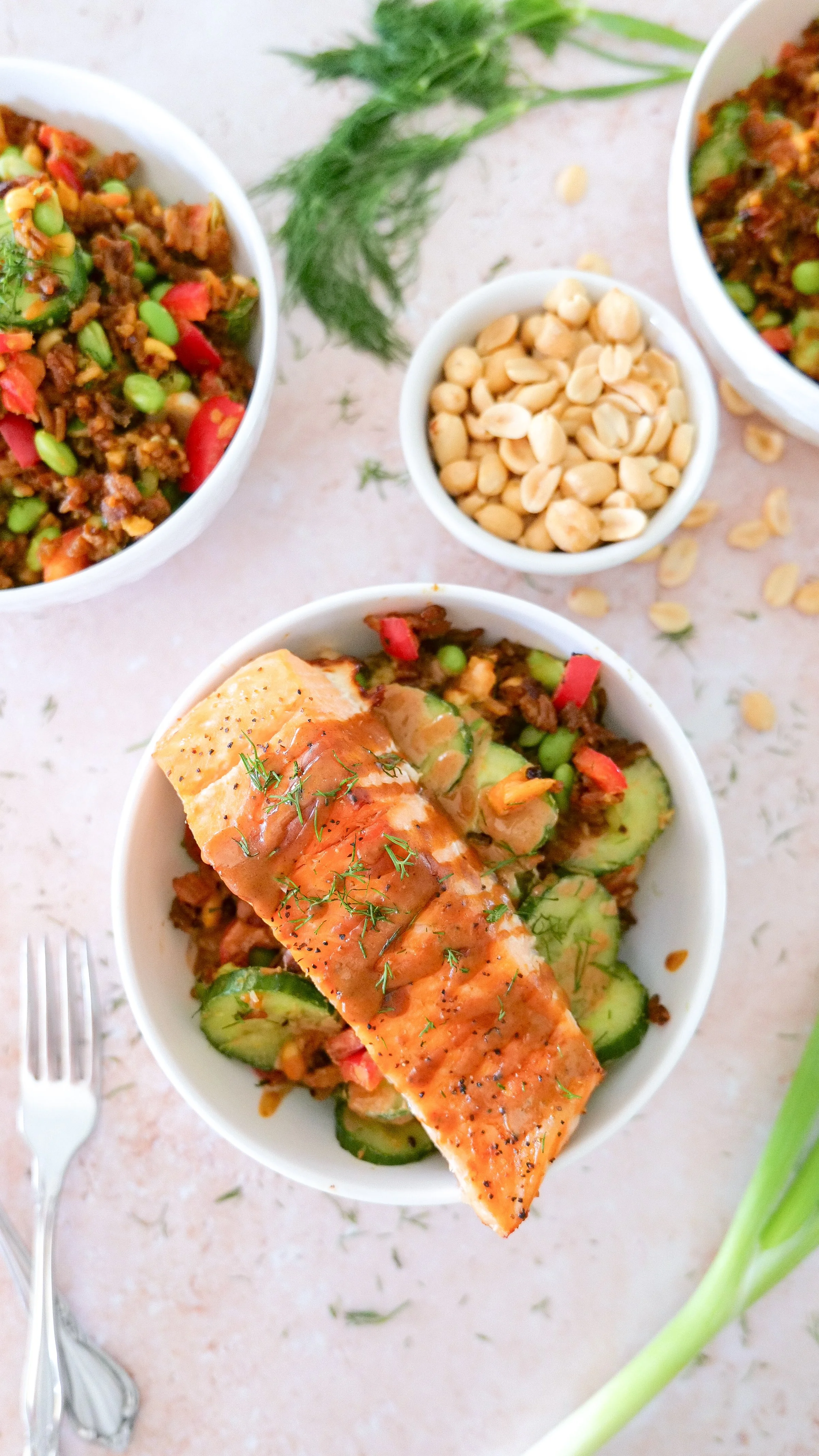 Overhead view of crispy rice salmon bowl with avocado, cucumber, bell pepper and edamame.