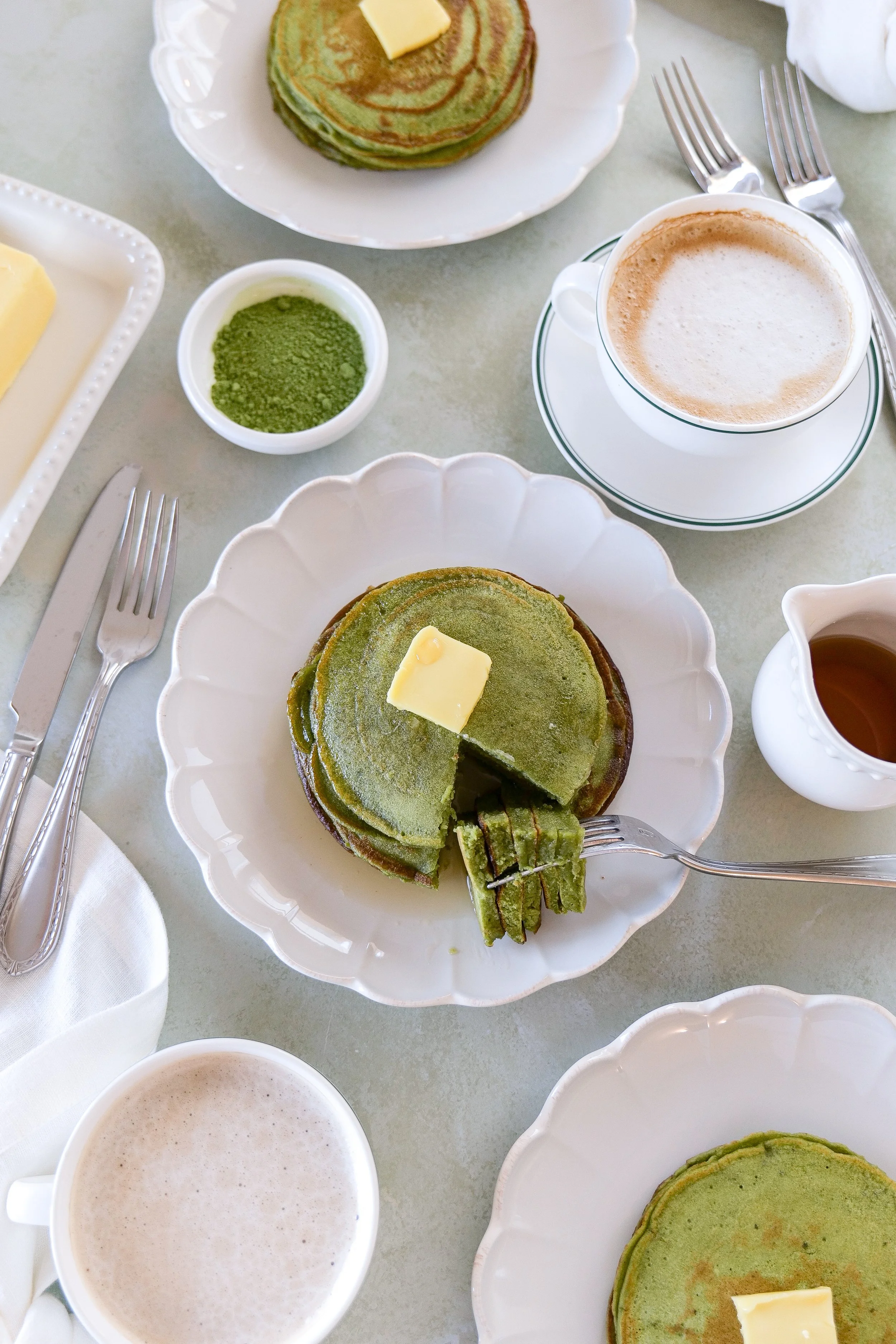 Fork cutting into soft matcha sourdough discard pancakes