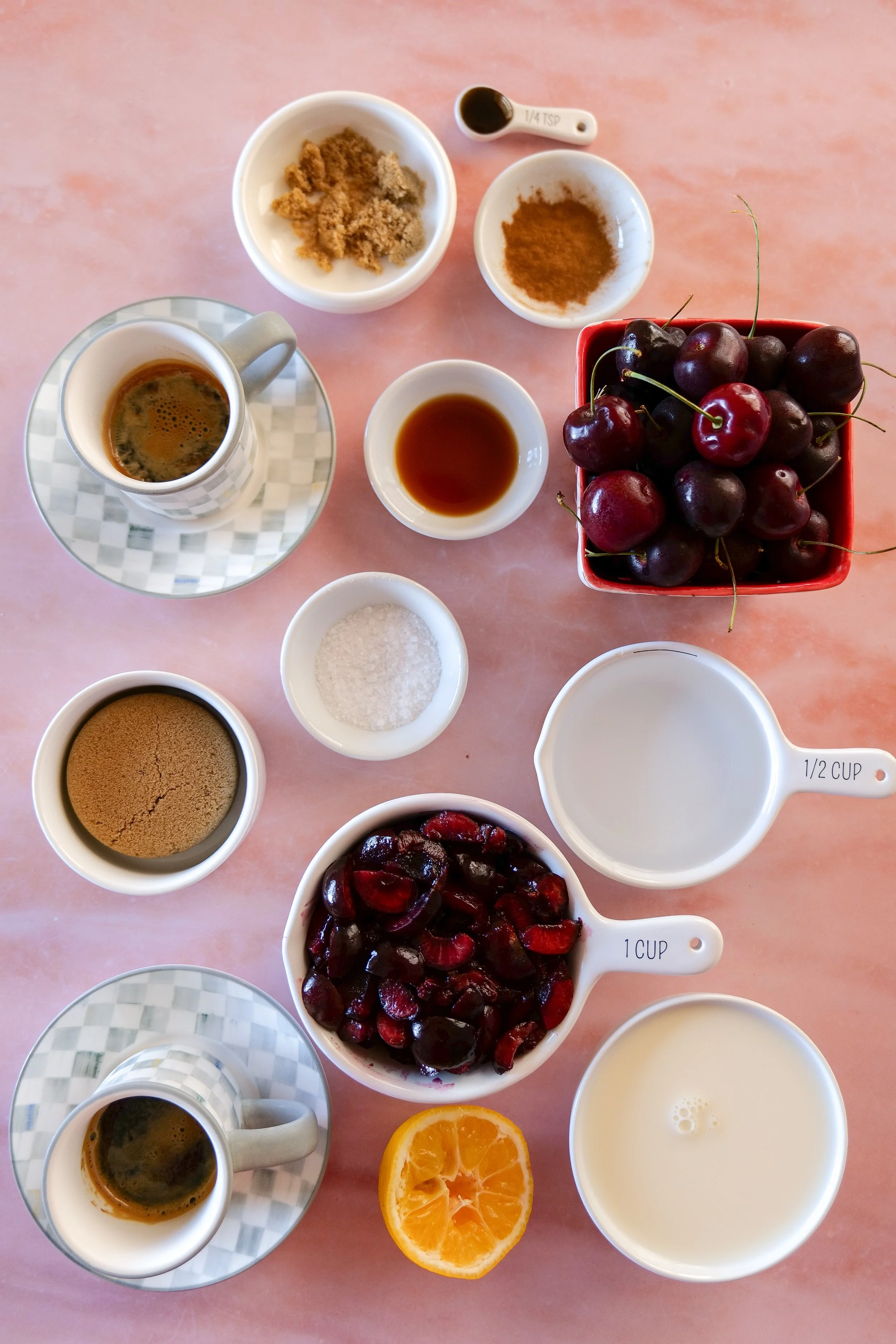 Iced latte topped with fluffy homemade cherry cold foam and fresh cherries.