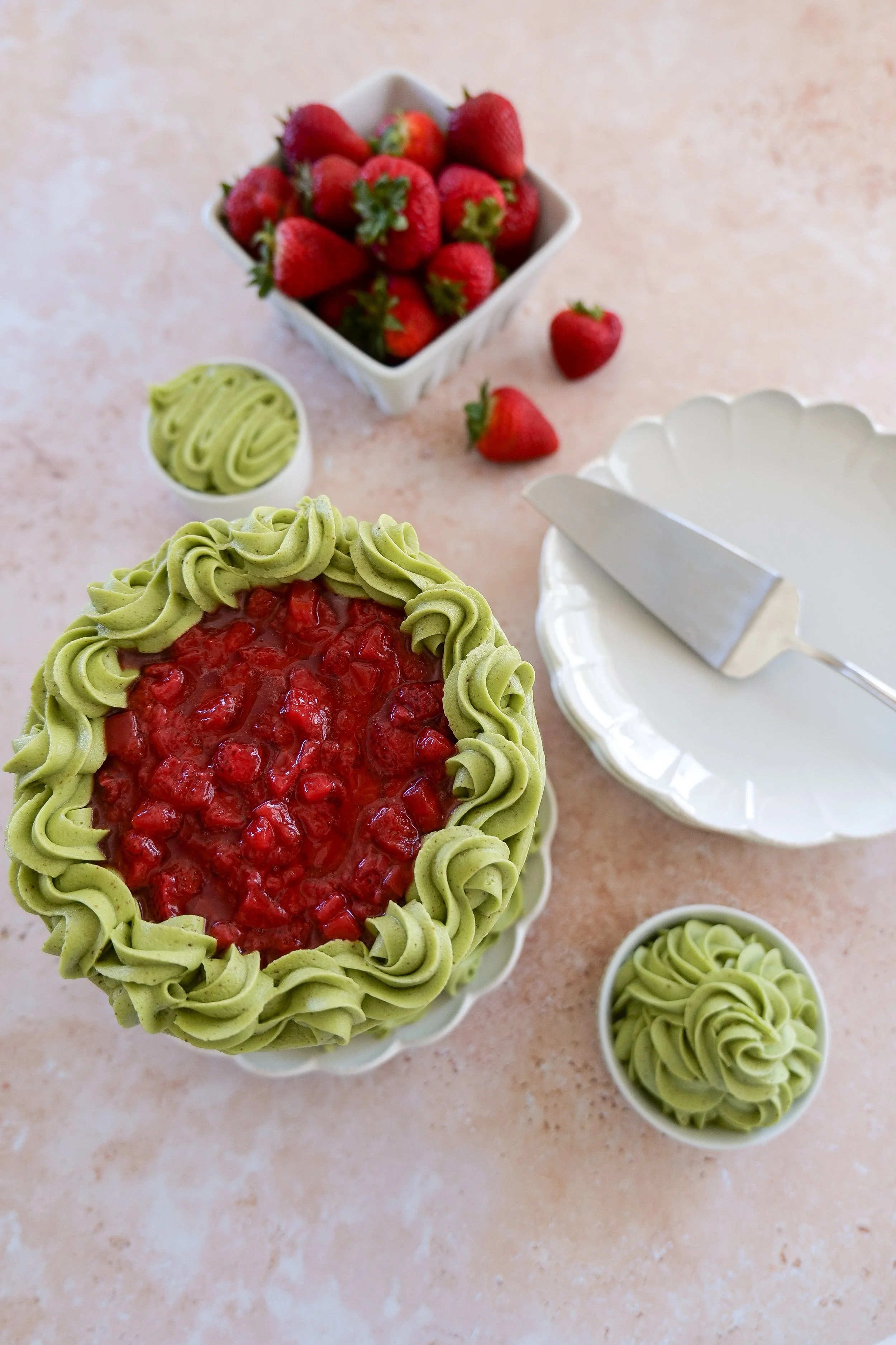 matcha strawberry cake featuring a green tea frosting and a strawberry topping