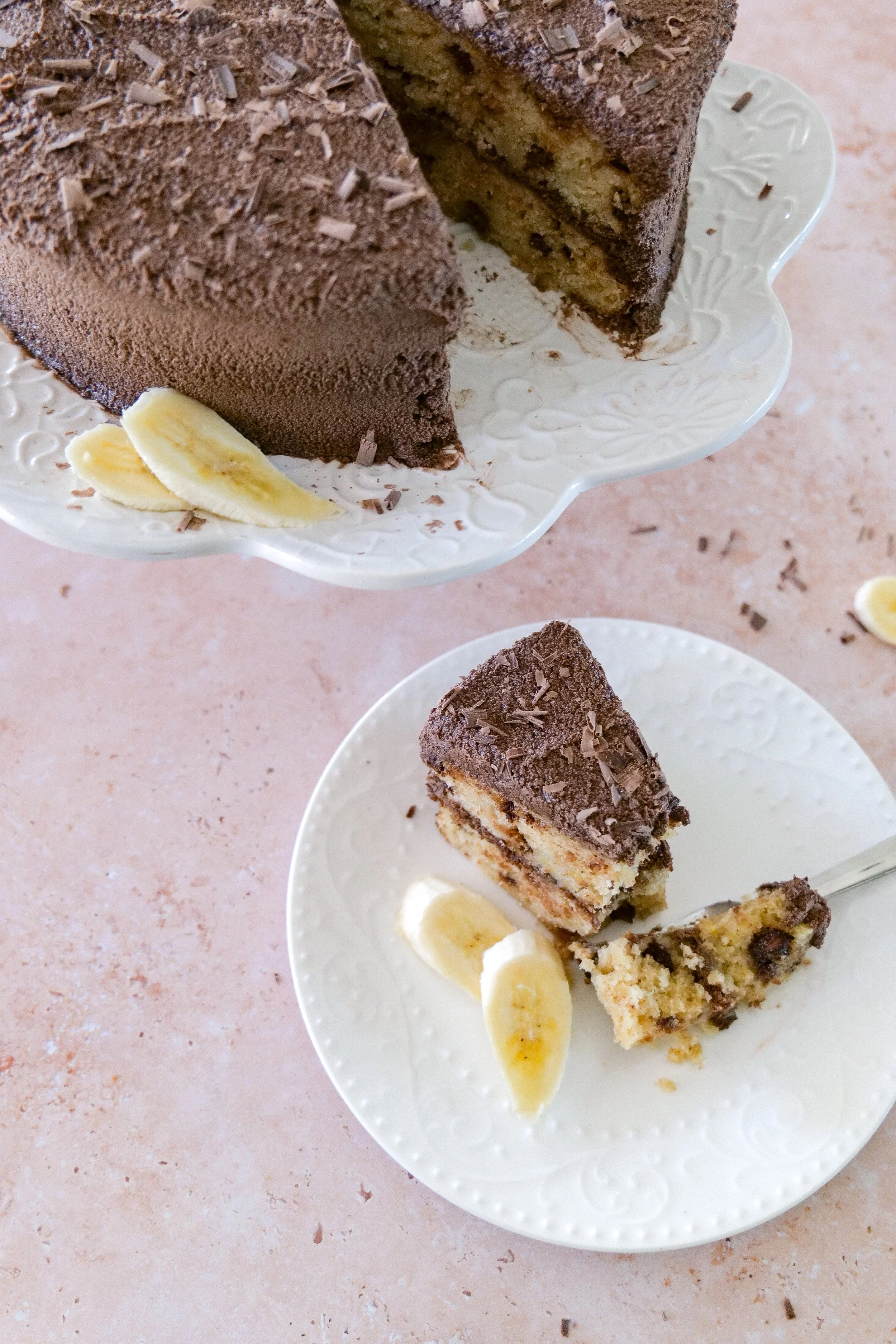 Banana chocolate chip layer cake with whipped chocolate ganache frosting and chocolate shavings.