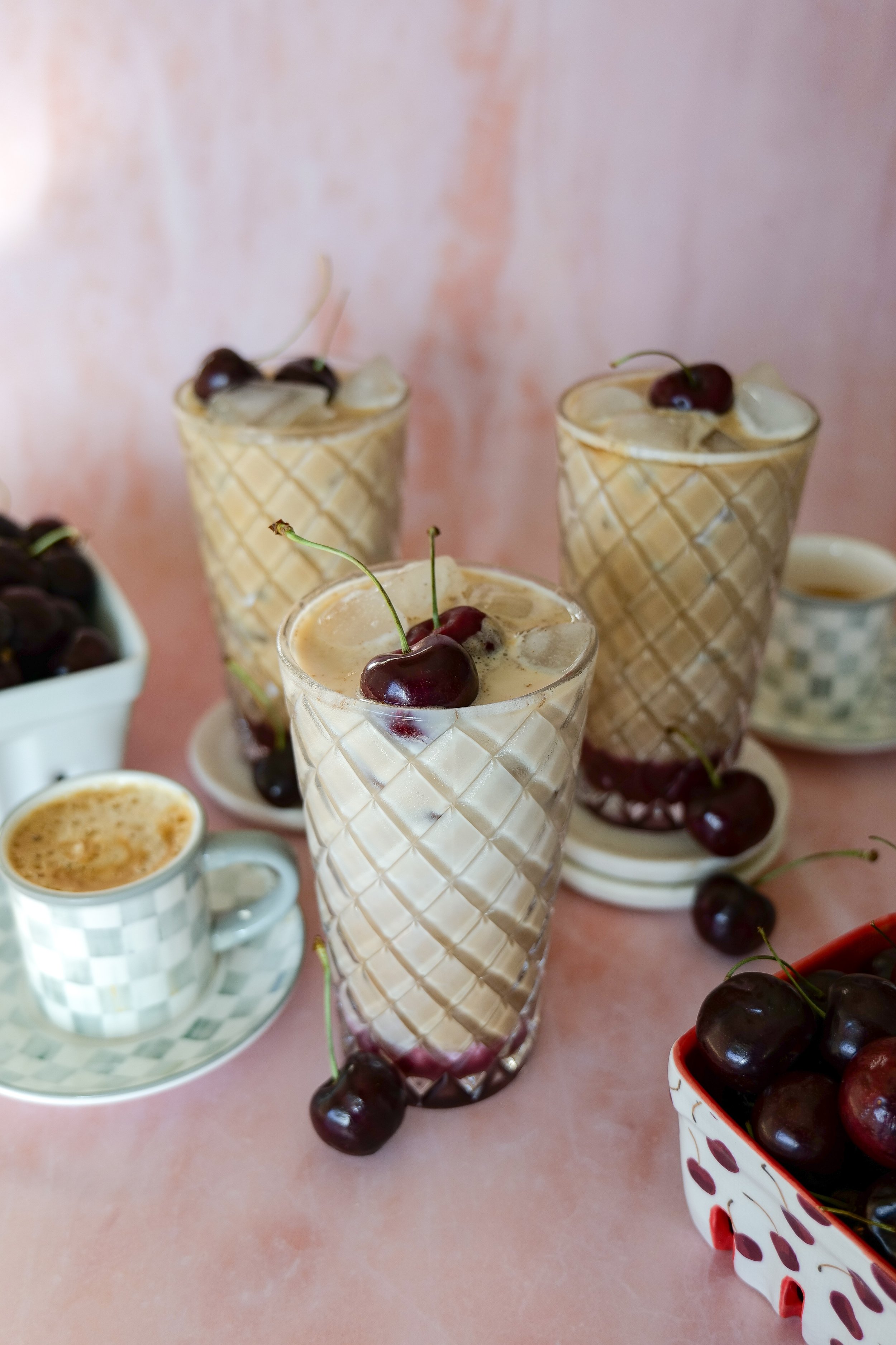 Refreshing iced cherry latte finished with creamy vanilla cold foam and cherry garnish.