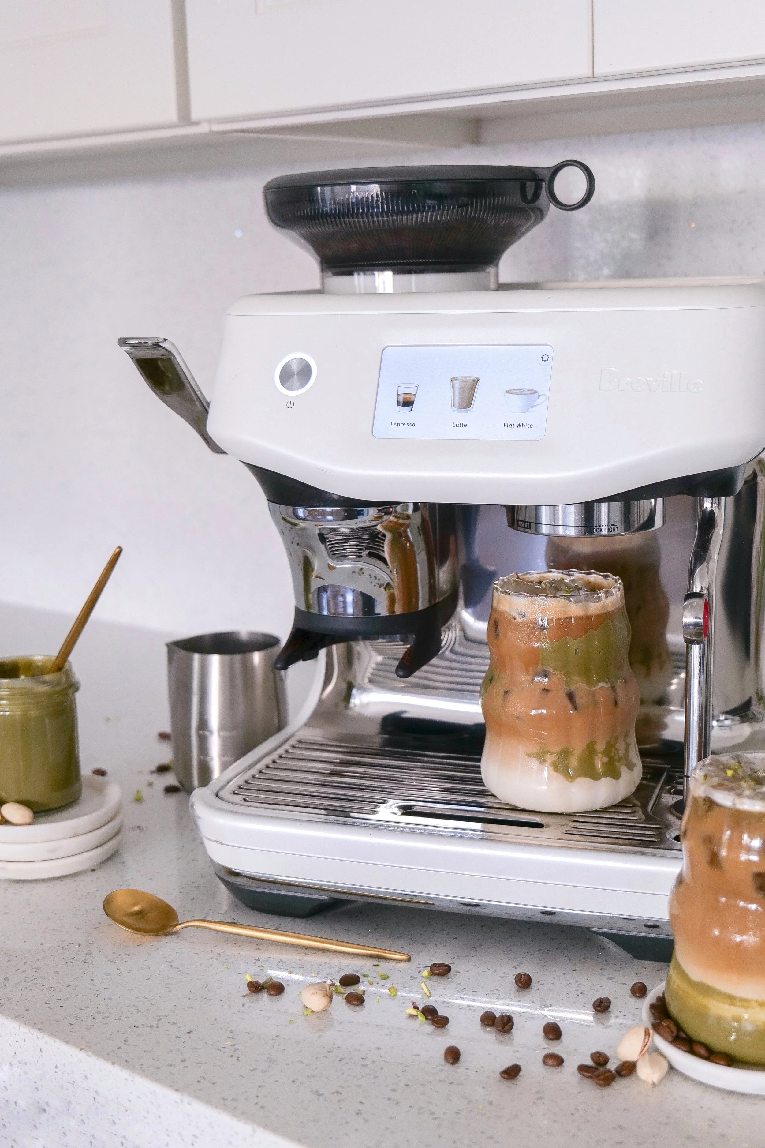 Iced pistachio coffee recipe served over plenty of ice in a clear glass.