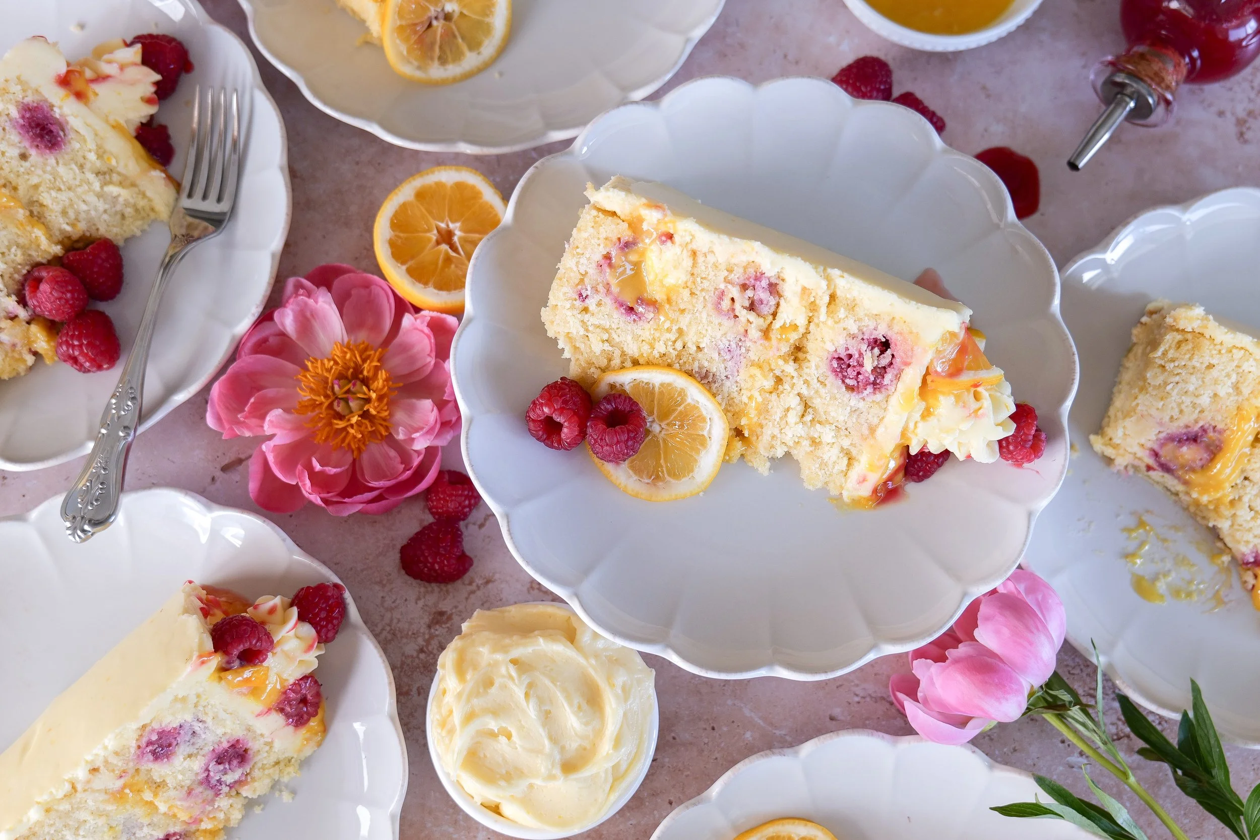 Close-up lemon cake slice with raspberries and lemon curd filling.