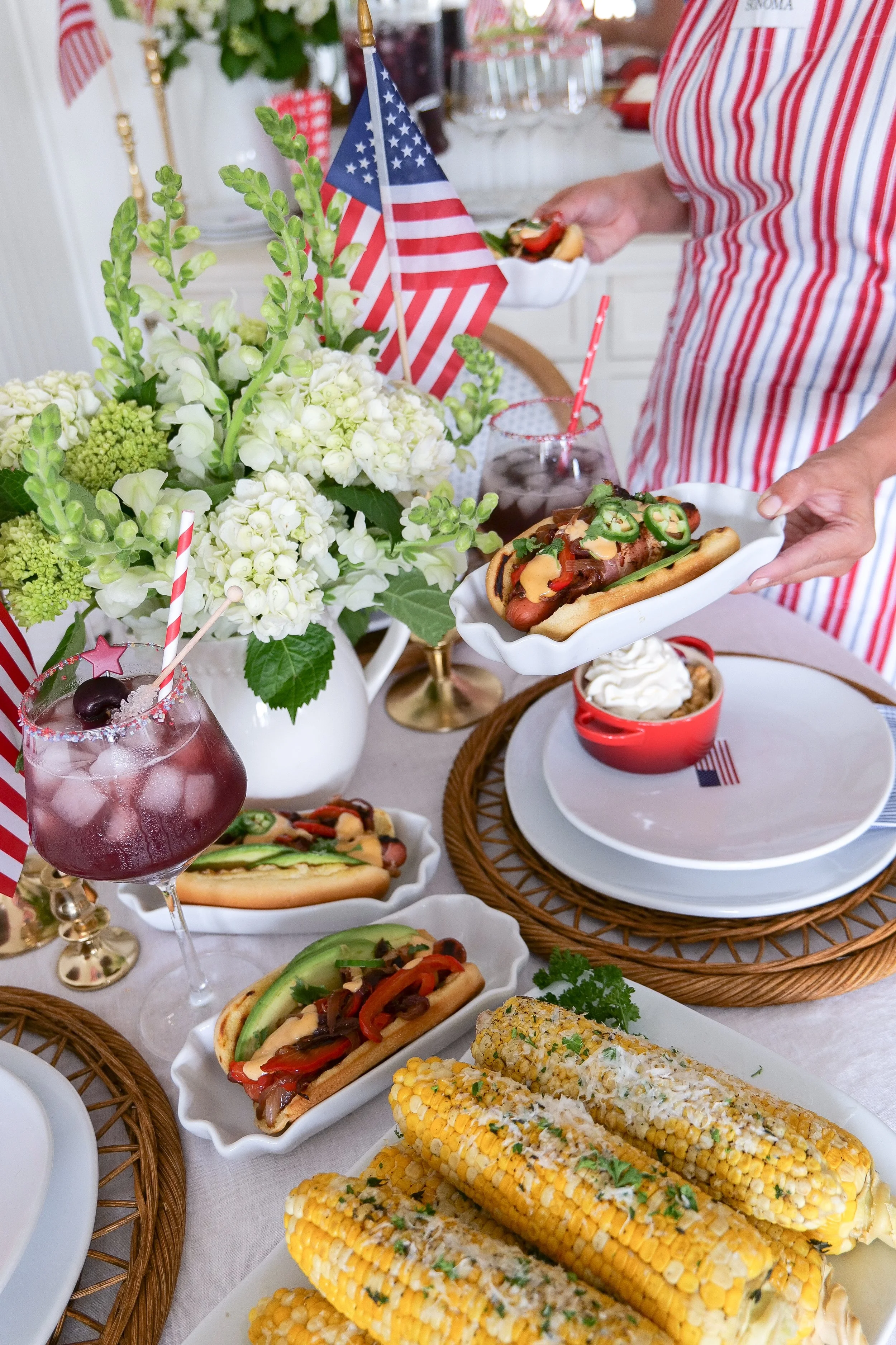 Bacon-wrapped hot dogs displayed on a Fourth of July tablescape