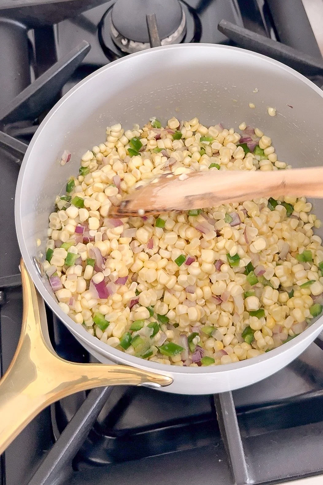 Fresh corn cooking in a skillet for homemade elote-inspired corn salsa