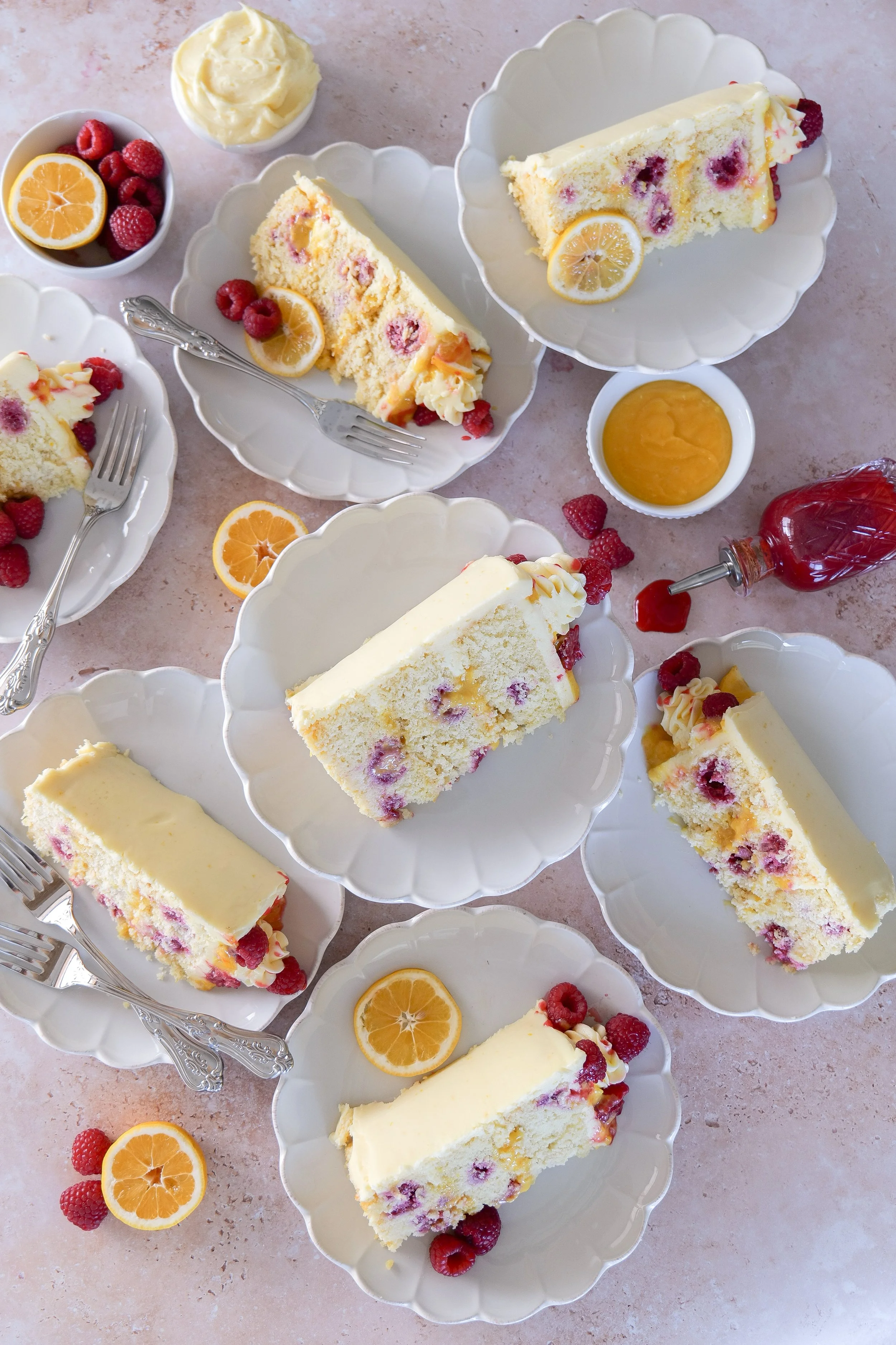 Lemon cake topped with fresh raspberries and creamy frosting.