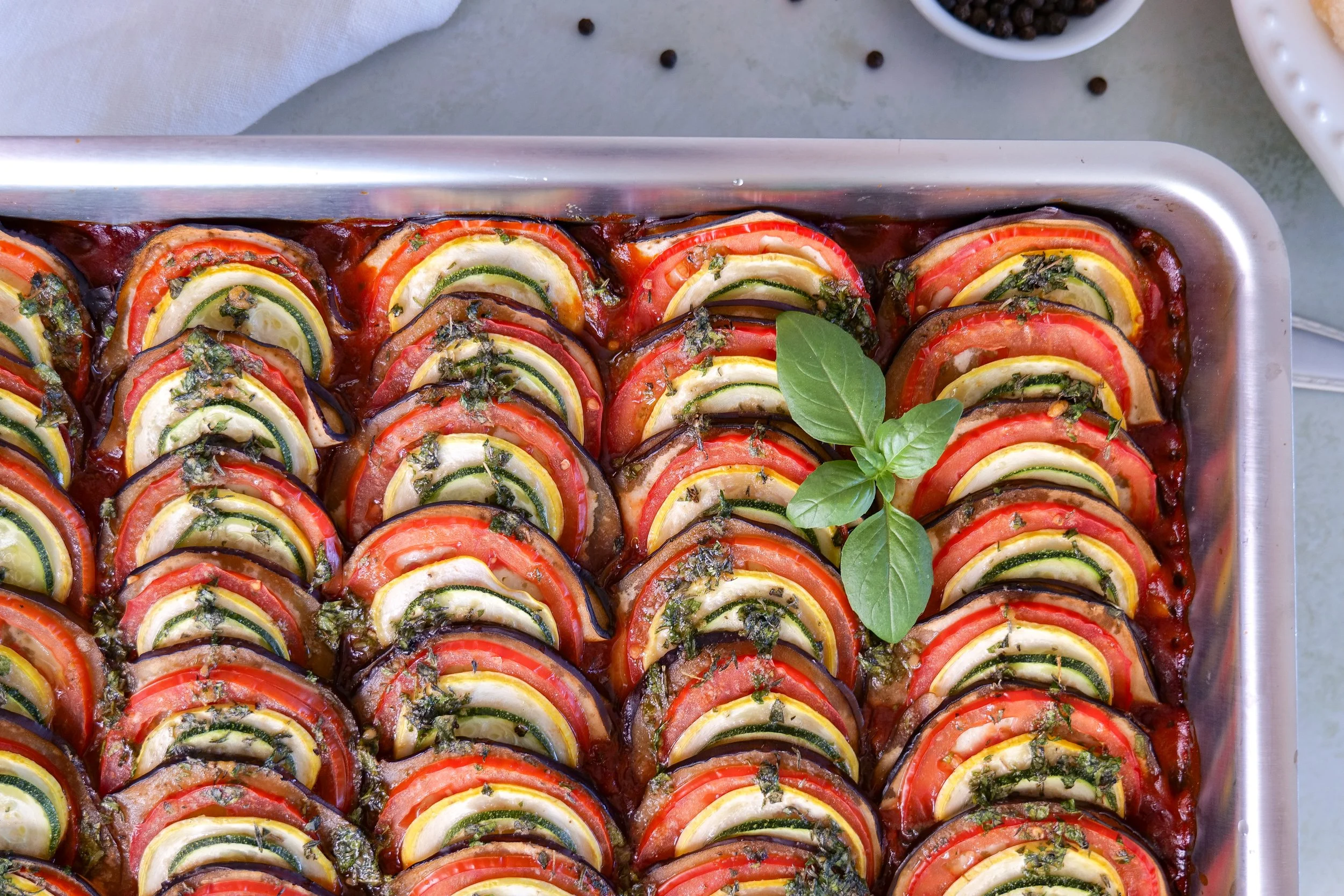 Fresh eggplant, zucchini, tomatoes, peppers, onion, garlic, and herbs from the farmers market for homemade ratatouille.