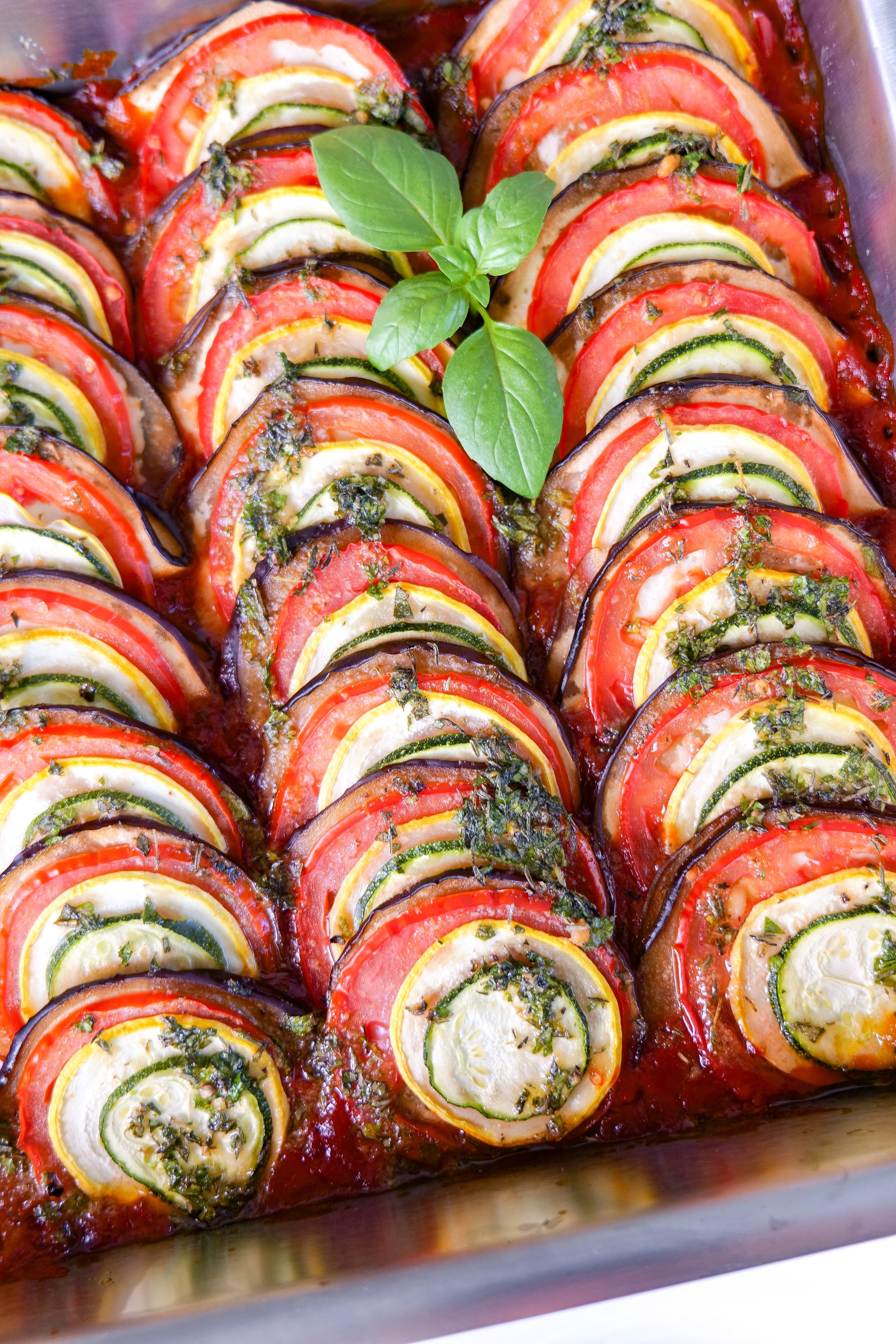 Homemade ratatouille garnished with fresh basil before serving.