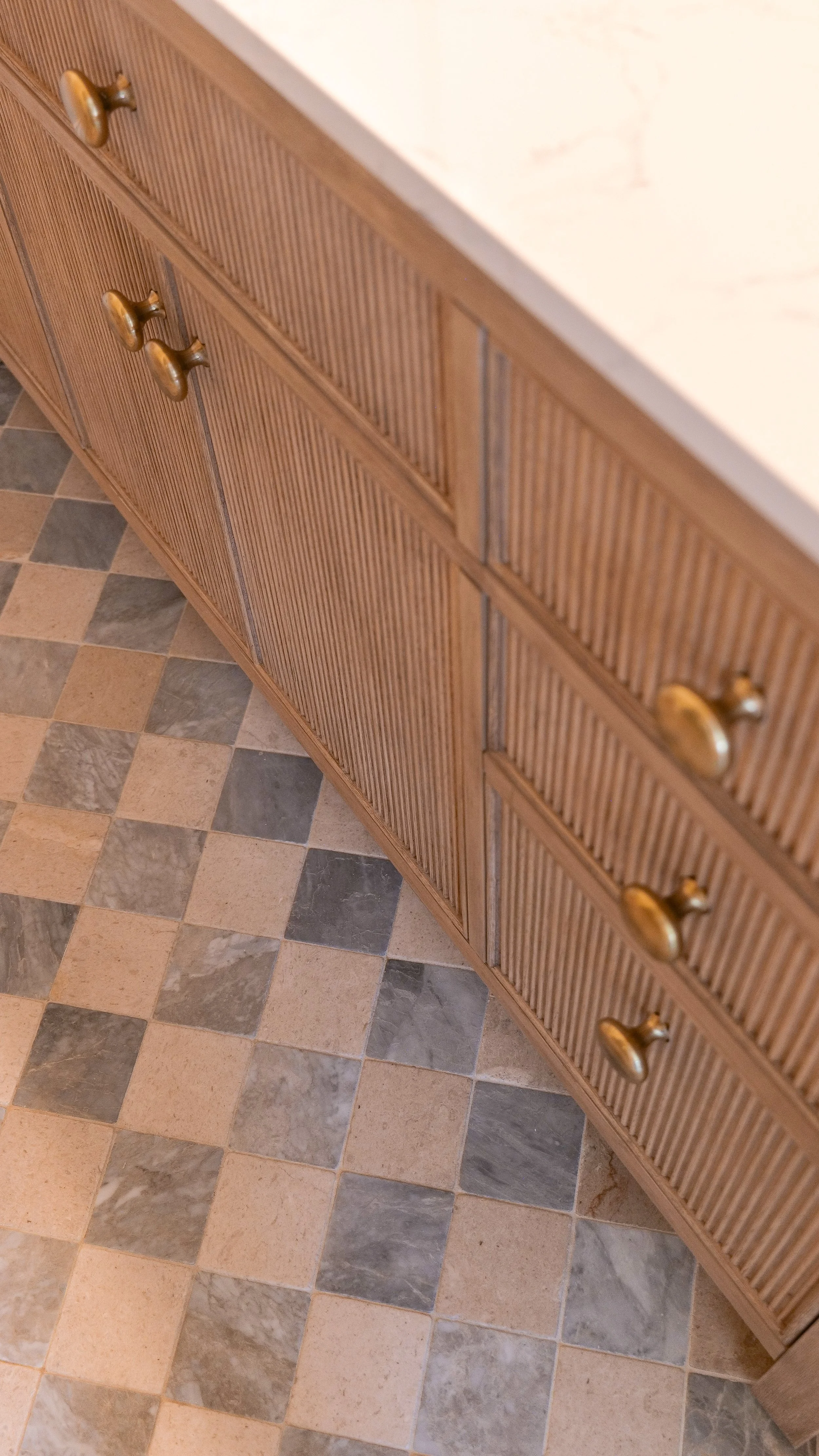 Bathroom floor tile with blue and warm tan tones beside the vanity.