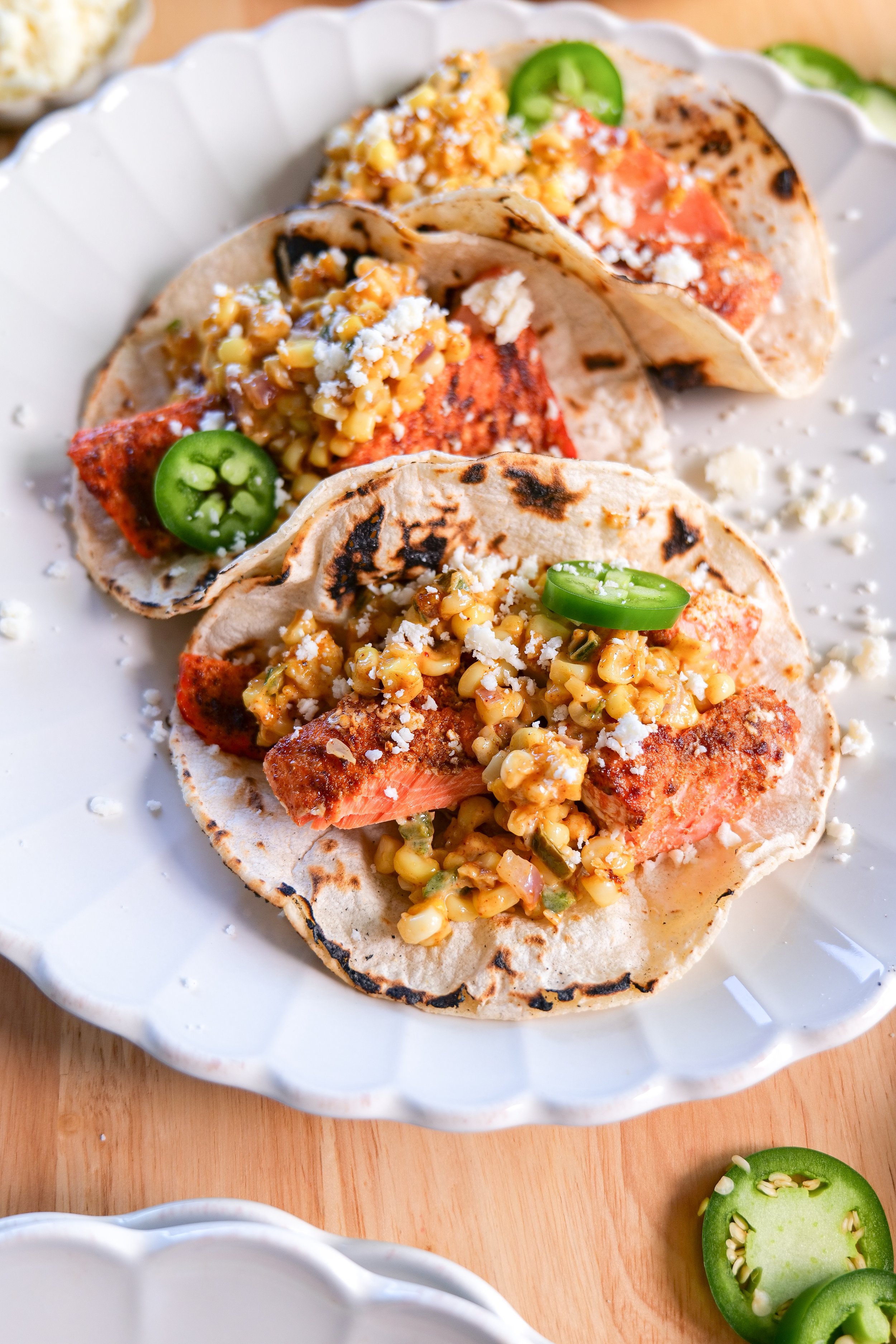 Close-up of salmon tacos filled with tender seasoned salmon and creamy Mexican street corn salsa.