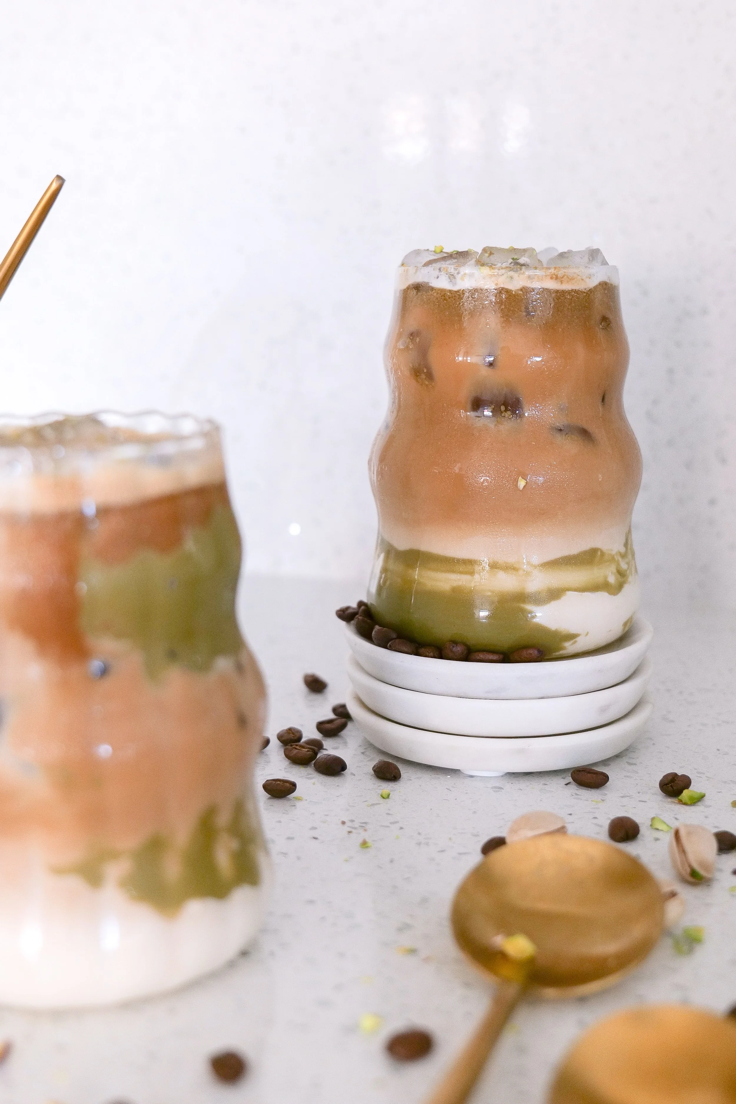 Homemade iced latte with pistachio cream, espresso, and a creamy milk mixture.