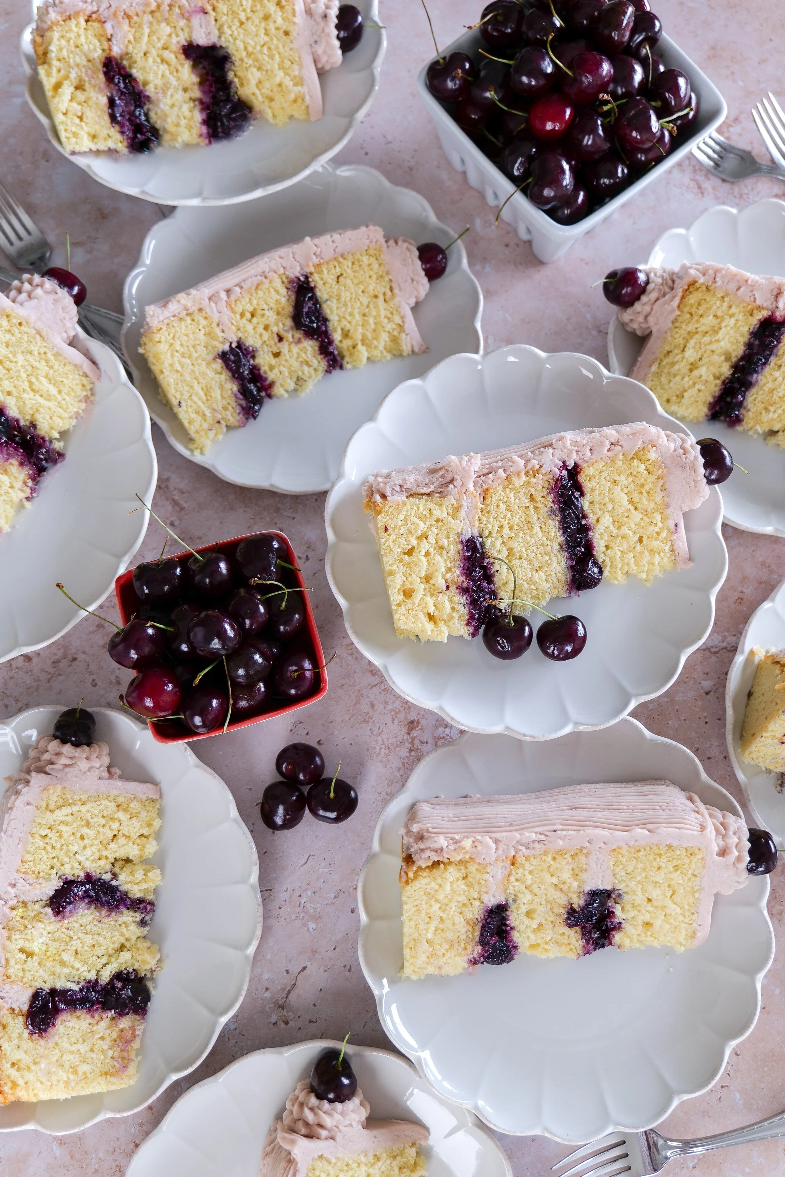 Close-up of vanilla bean cherry cake with homemade cherry filling and soft pink buttercream.