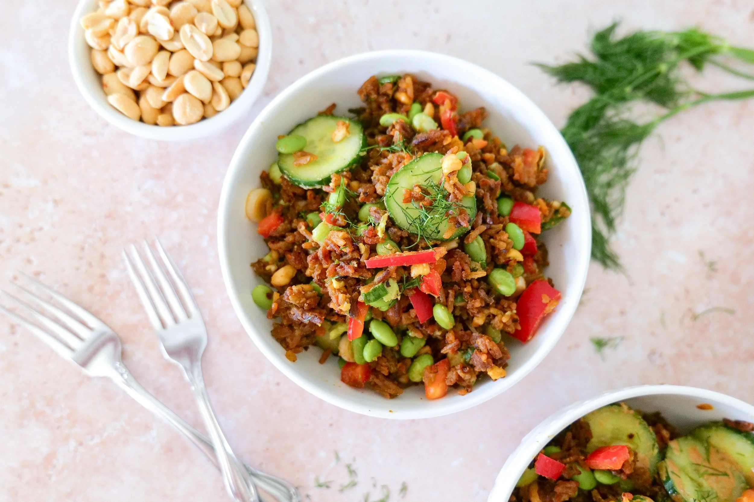 Salmon rice salad with avocado, cucumber, edamame, crushed peanuts and peanut sauce.
