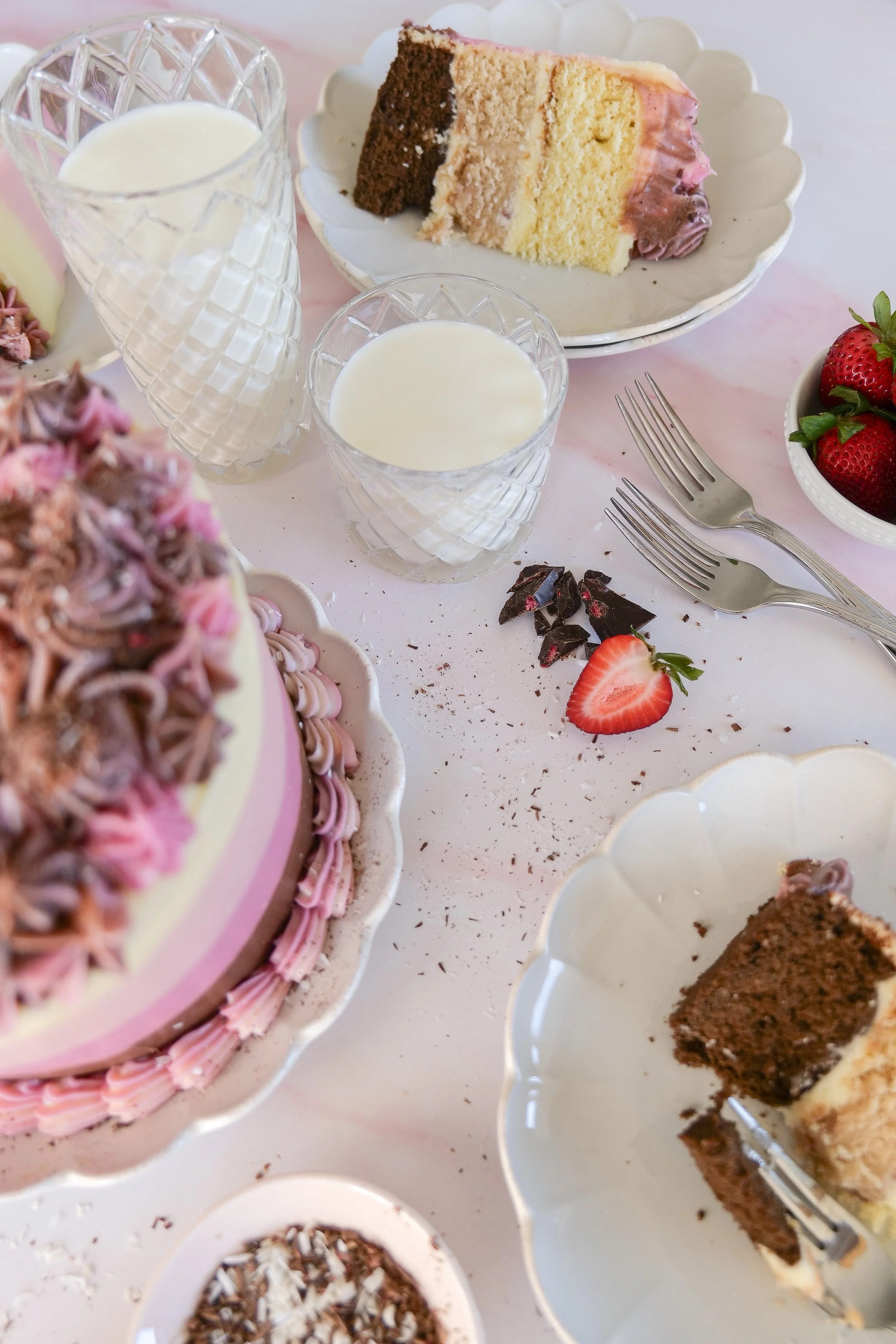 Chocolate, vanilla, and strawberry layer cake sliced to reveal the three classic Neapolitan flavors.