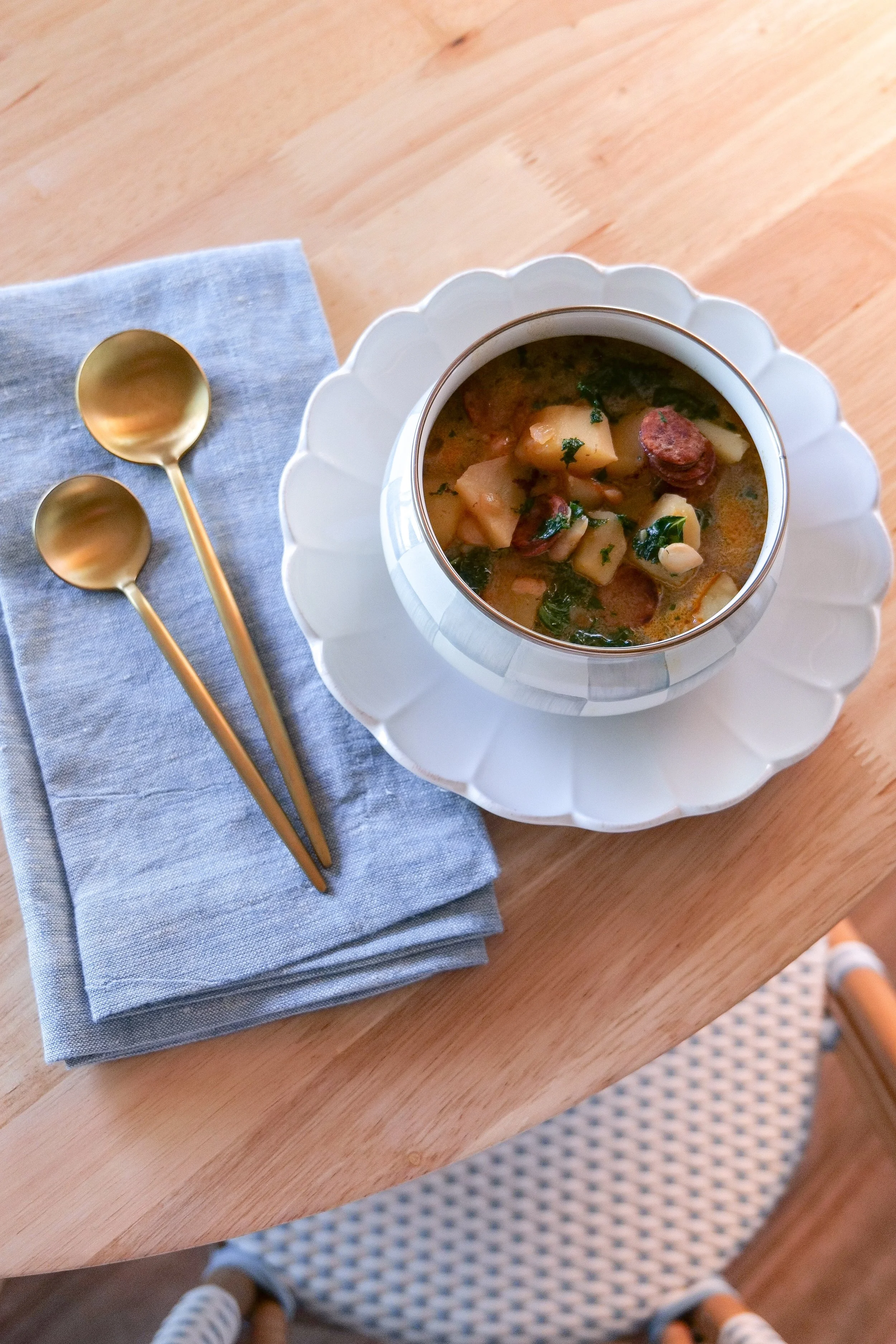 Linguiça potato and kale soup served warm with white beans in a savory broth.