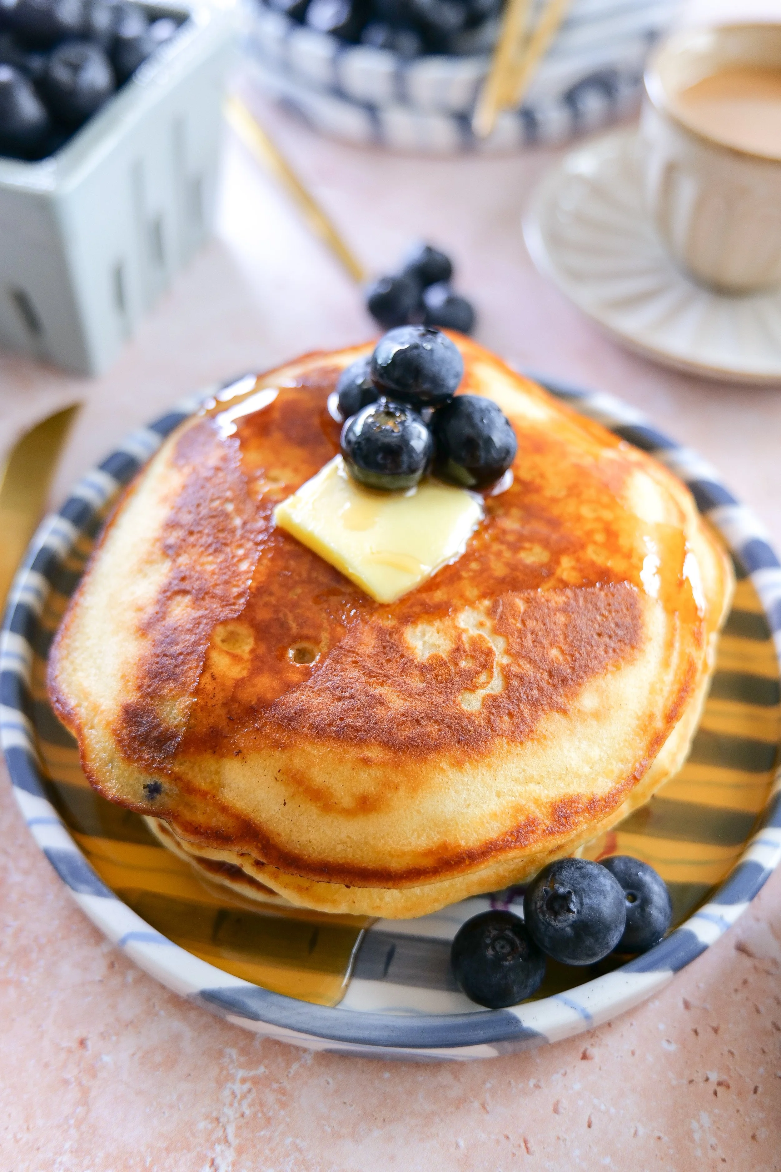 Fluffy homemade blueberry pancakes served with butter and syrup.