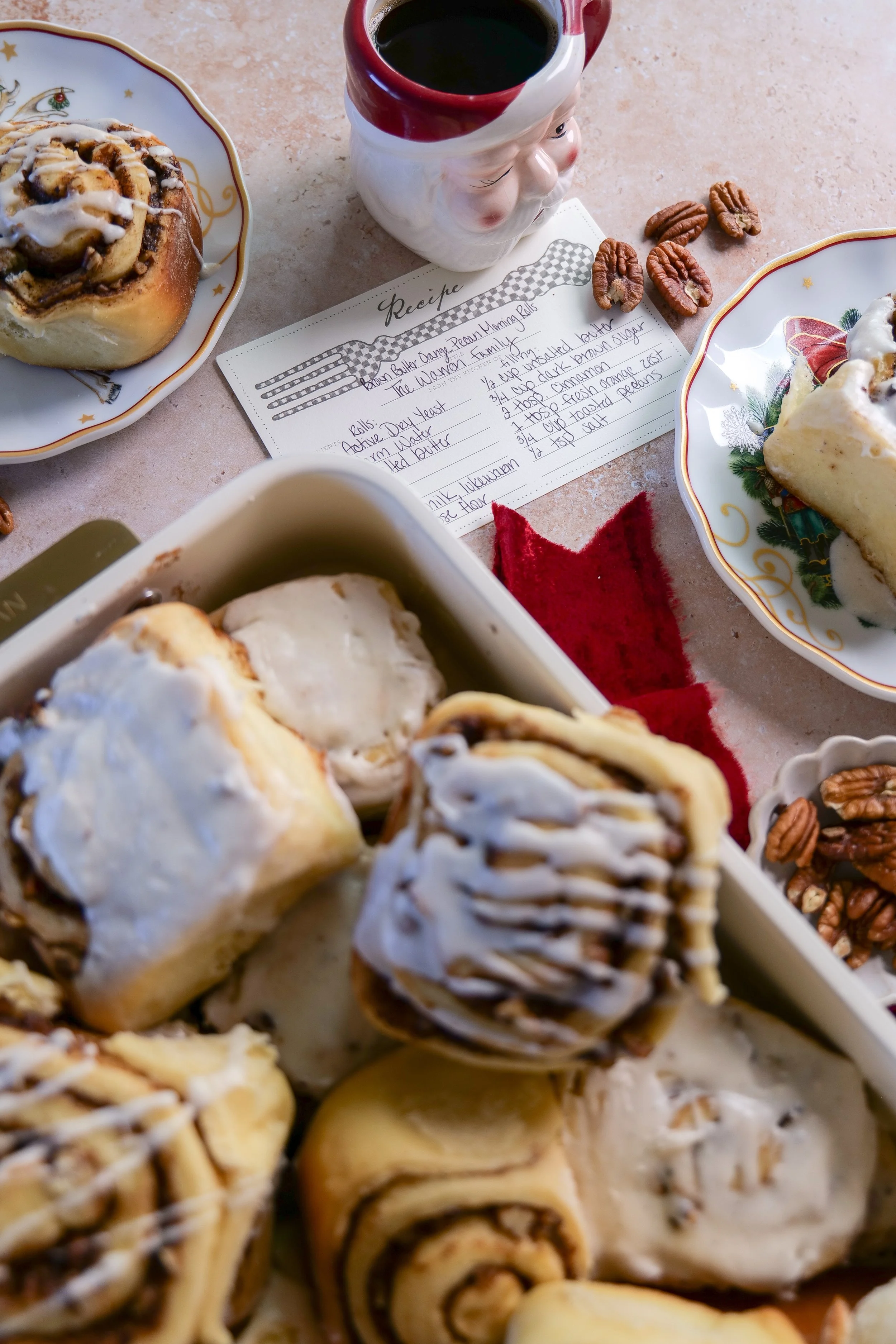 Close-up of soft orange pecan cinnamon rolls with cinnamon swirls and creamy vanilla bean glaze.
